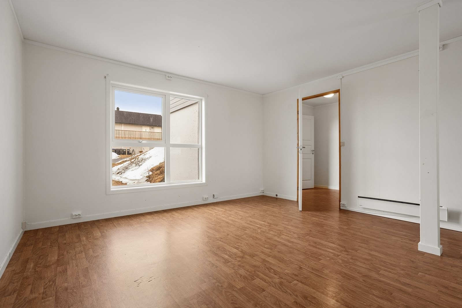 Stuen er utført i lyse, tidløse farger og har et vindu som slipper inn rikelig med naturlig lys, noe som gir rommet en luftig og behagelig atmosfære Galleribilde