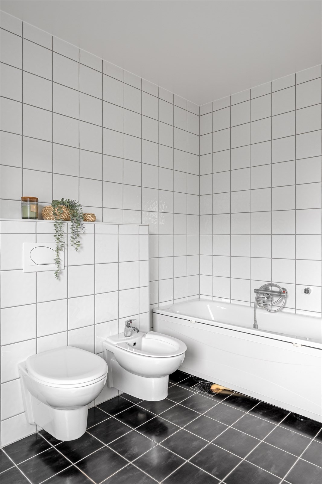 Badet er innredet med servant, vegghengt toalett, dusjhjørne med glassdører samt badekar - perfekt for avslapning etter en lang dag. Galleribilde
