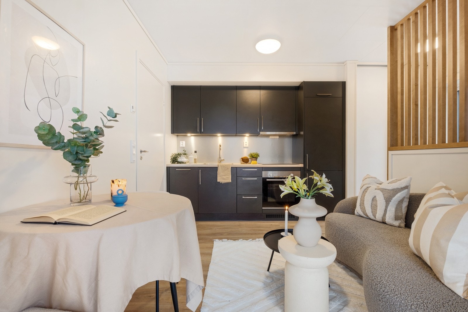 Kjøkkenet har en moderne innredning med mørke glatte fronter og benkeplate i laminat med nedfelt kjøkkenvask Galleribilde