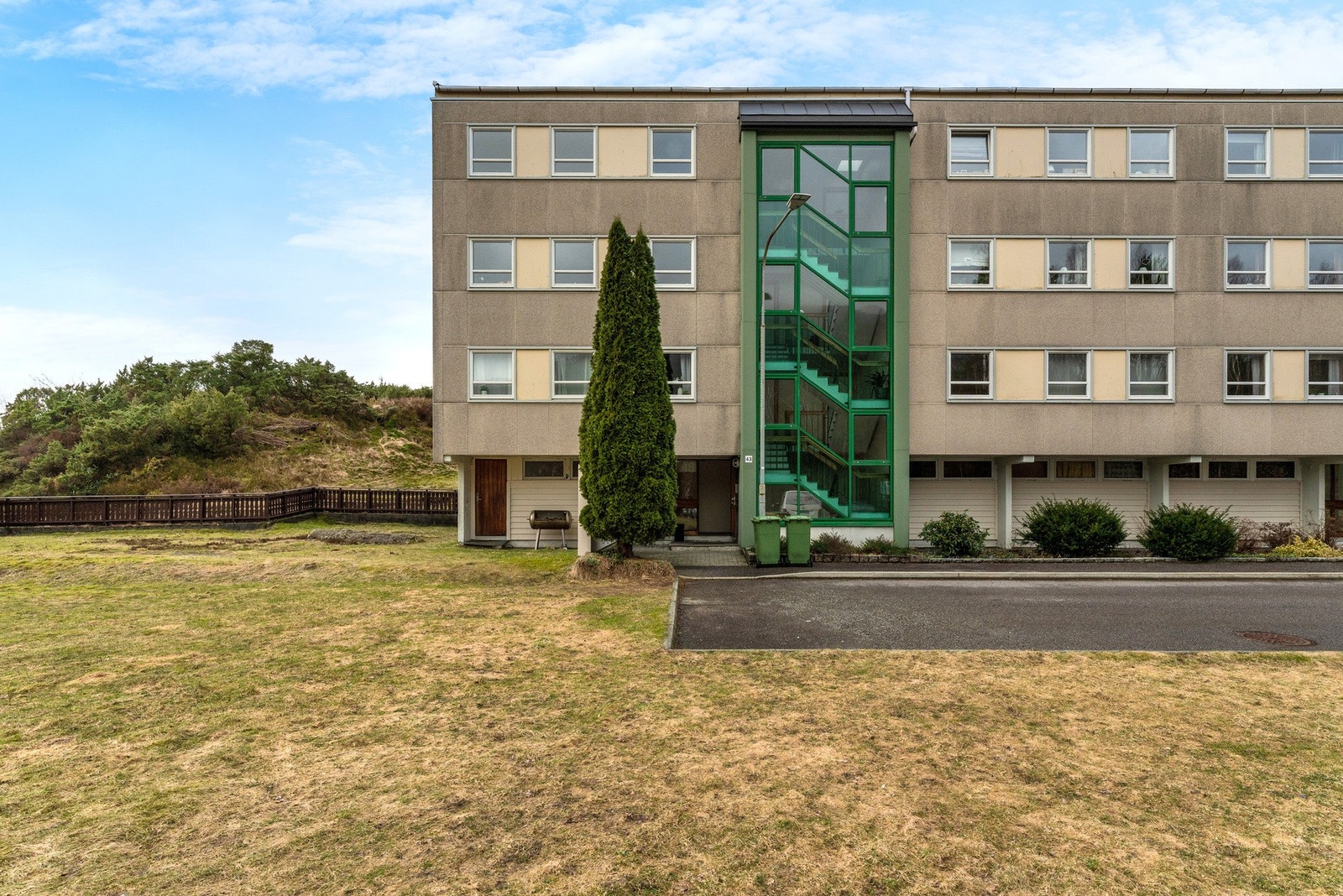 Leiligheten ligger helt på enden av borettslaget, der bygget også er på enden av rekken. Luftige grøntområder på siden hvor kaffen kan nytes i morgensolen Galleribilde