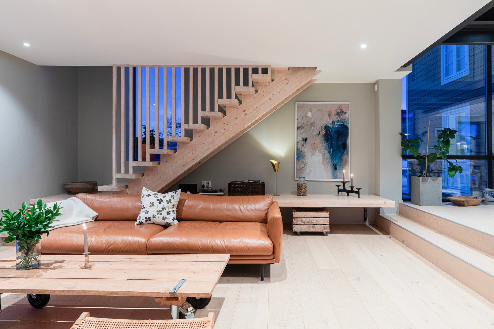 Valg av materialer i boligen forsterker den lune og gode følelsen - bred énstavs eikeparkett, samt en solid trapp i heltre furu opp til 2.etasje. Plassbygget benk under trappa, som både dekorativ og praktisk. Galleribilde