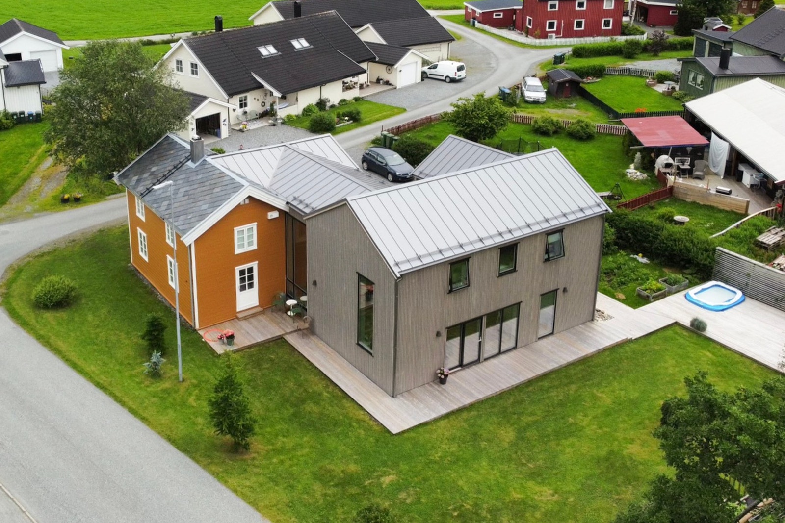 Eiendommen har en flat, solrik og pent opparbeidet tomt - som samtidig også er lettstelt. Flott terrasse rundt store deler av tilbygget, med utganger til denne fra både kjøkkenet og i selve stua. Galleribilde