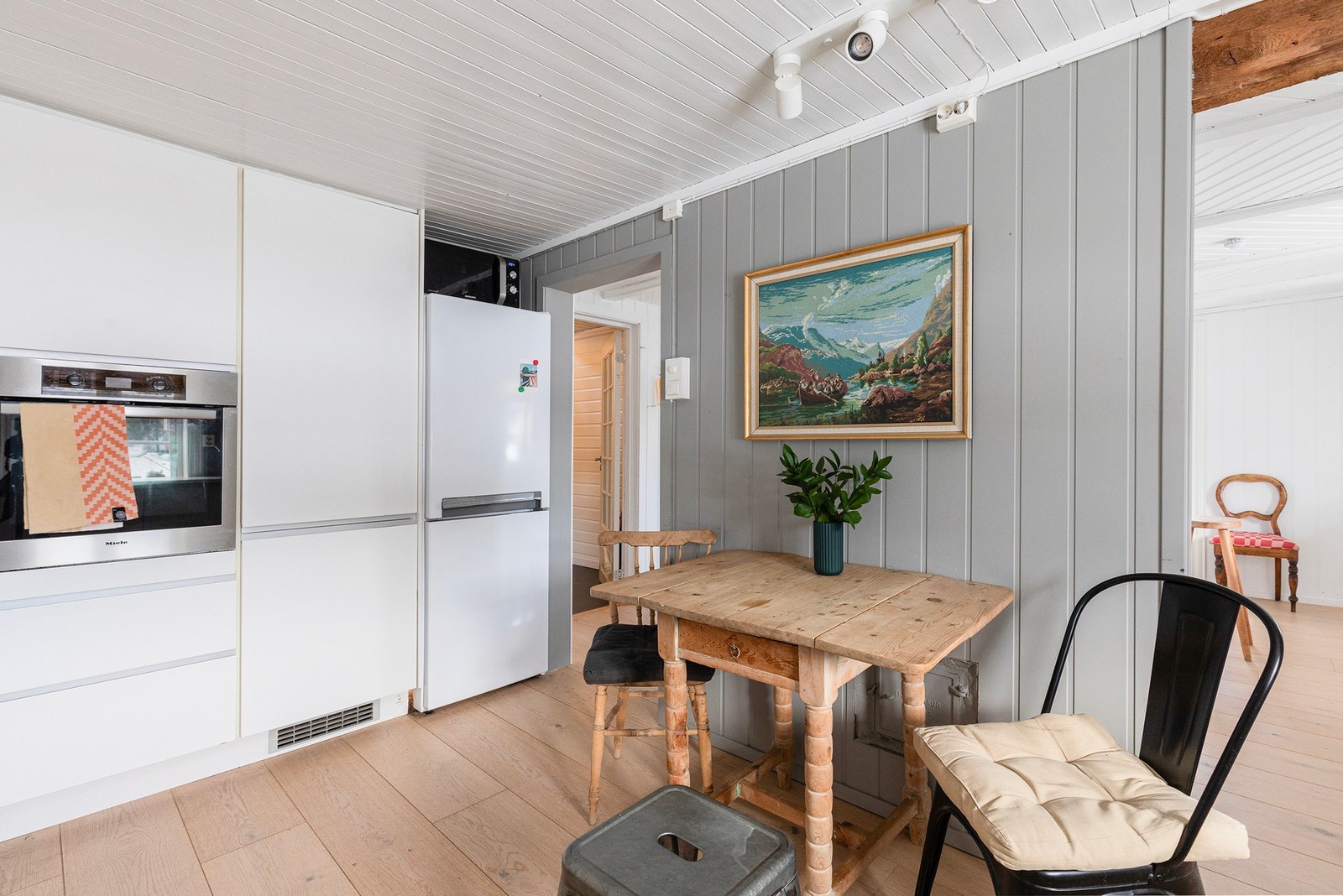 Det er lagt sammenhengende samme gulv i hele 1. etasjen - fra kjøkkenet, til spisestua og videre ut til stua. Gjennomgående helhetsfølelse i hele boligen. Galleribilde