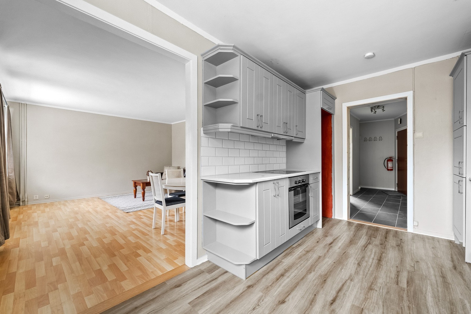 Kjøkkenet har rikelig med over- og underskap med lyse, profilerte fronter, samt laminat benkeplate og fliser mellom benk og overskap. Galleribilde