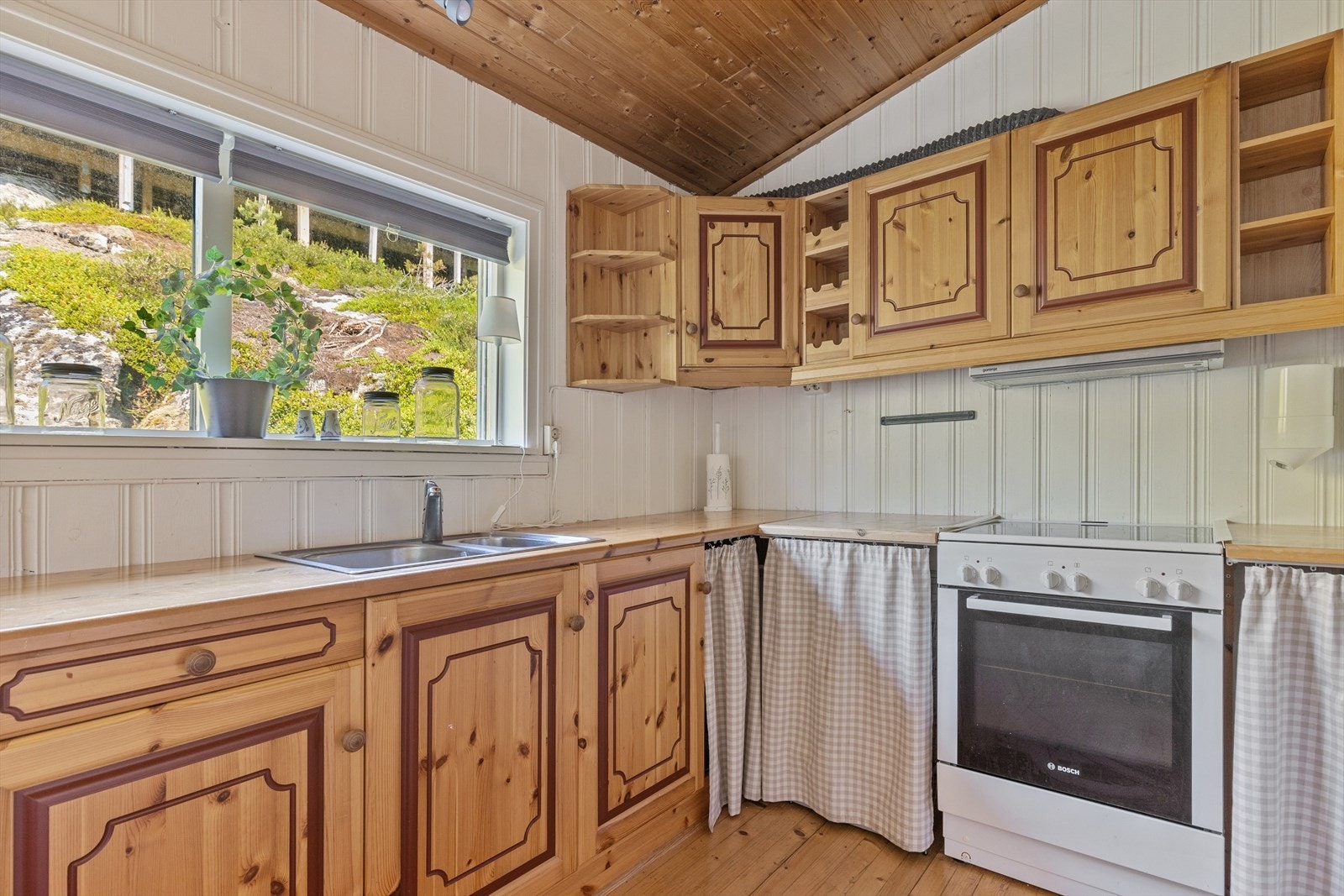 Fullverdig kjøkken med hvitevarer som komfyr og kjøleskap. Galleribilde