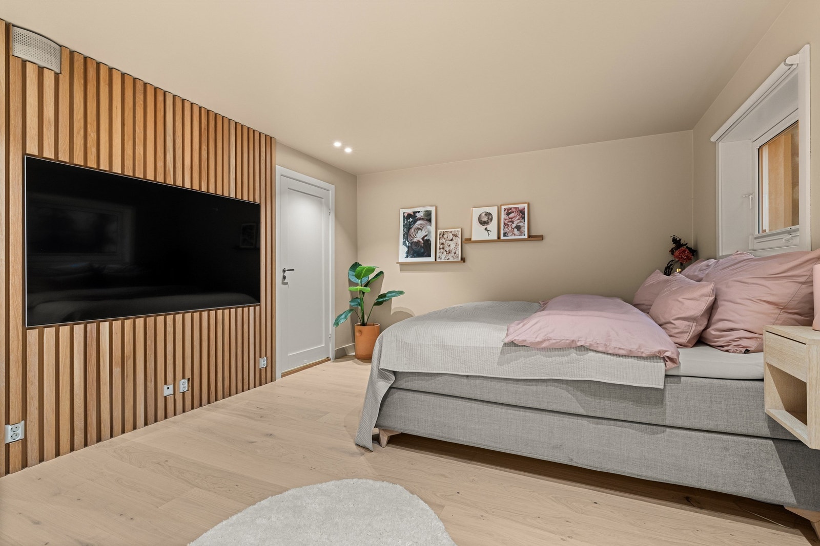 En spilevegg i tre gir rommet en varm og moderne karakter. I dette rommet finnes opplegg for hybelkjøkken. Galleribilde