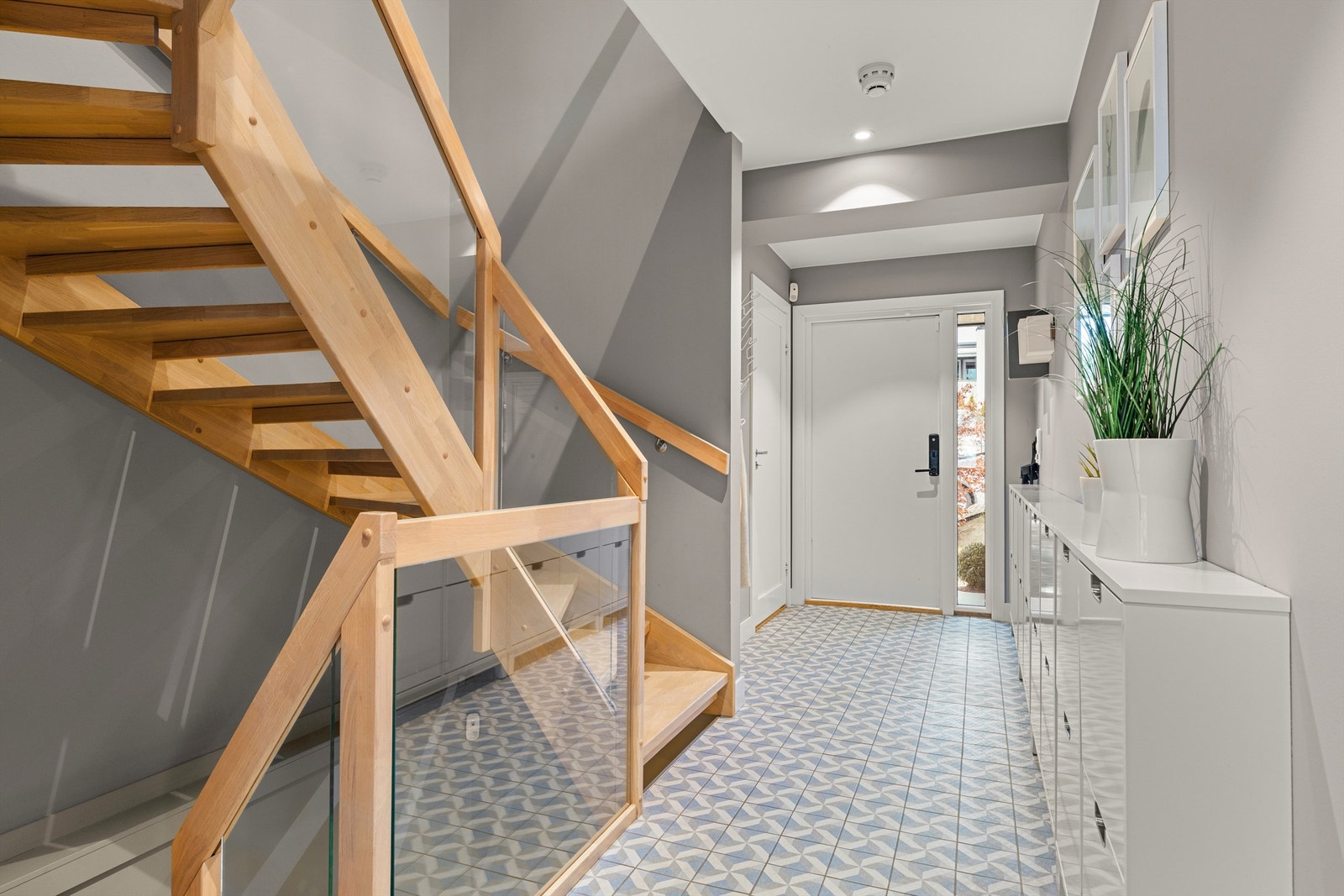 Velkommen inn i en romslig entré med mønstrede gulvfliser og trapp i heltre eik til de øvrige etasjene. Galleribilde