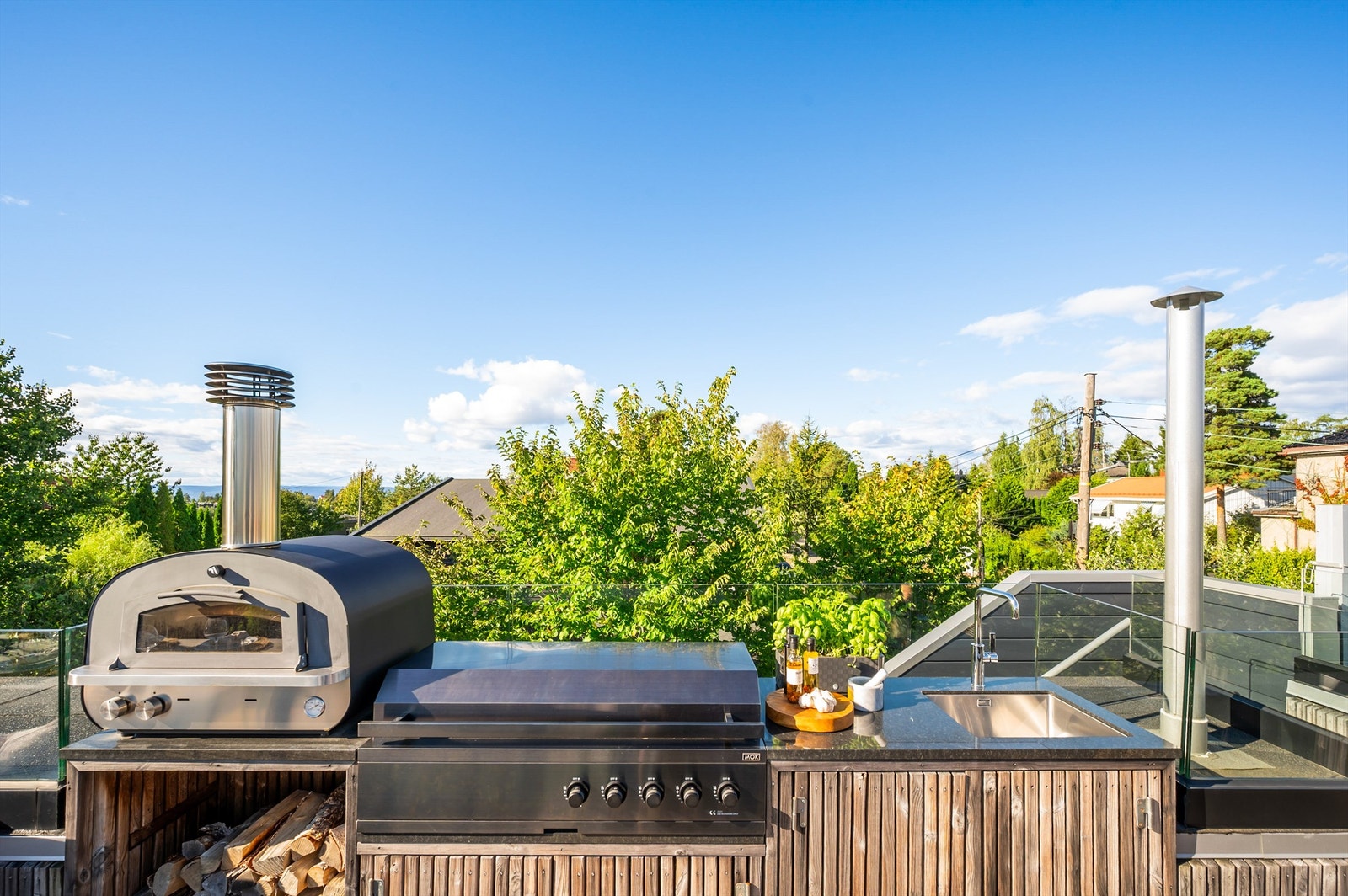 Terrassen er utstyrt med et plassbygget utekjøkken med plass til både pizzaovn og grill. Galleribilde