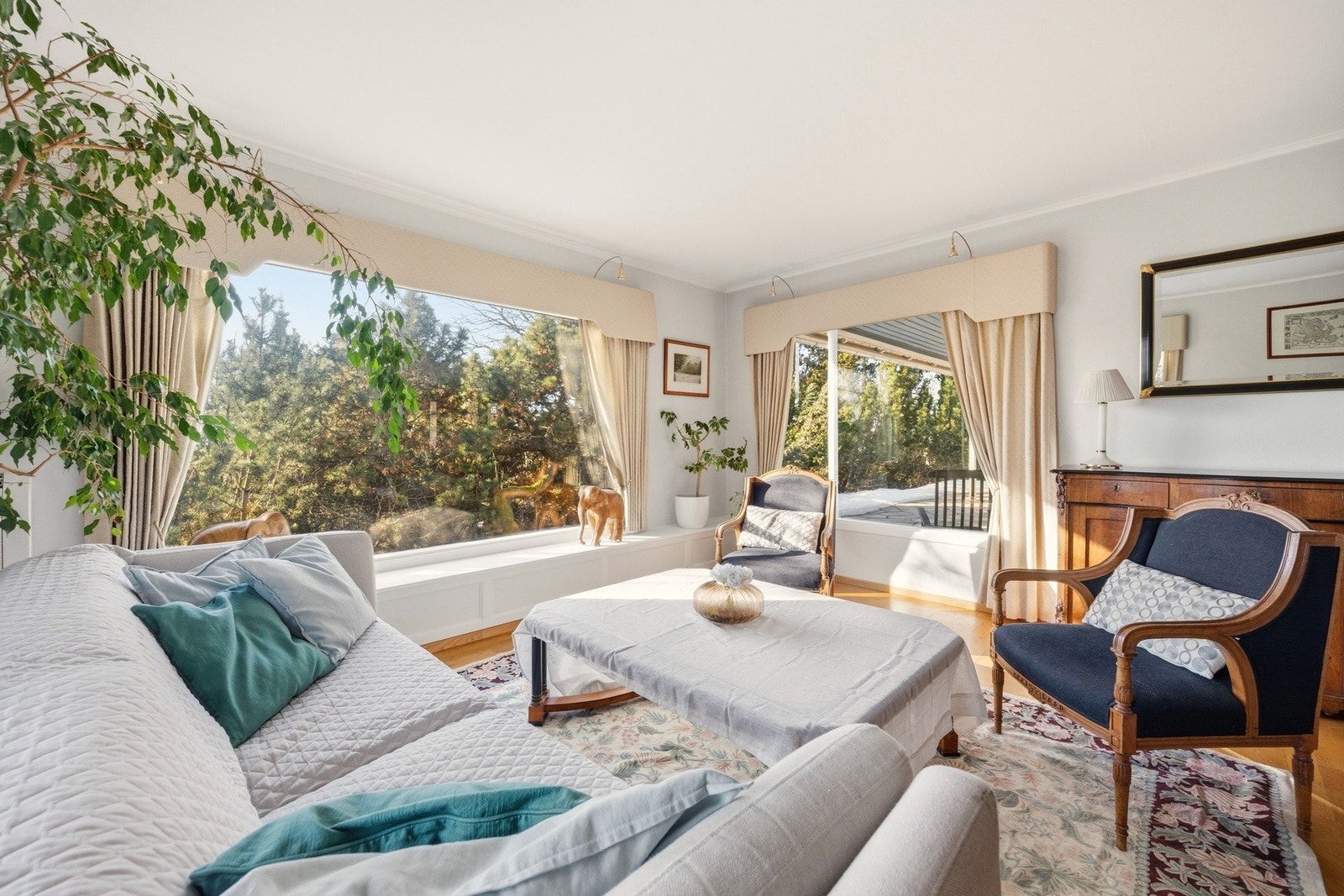 Boligen har en innbydende stue, med store vindusflater og lys fra tre kanter. Galleribilde