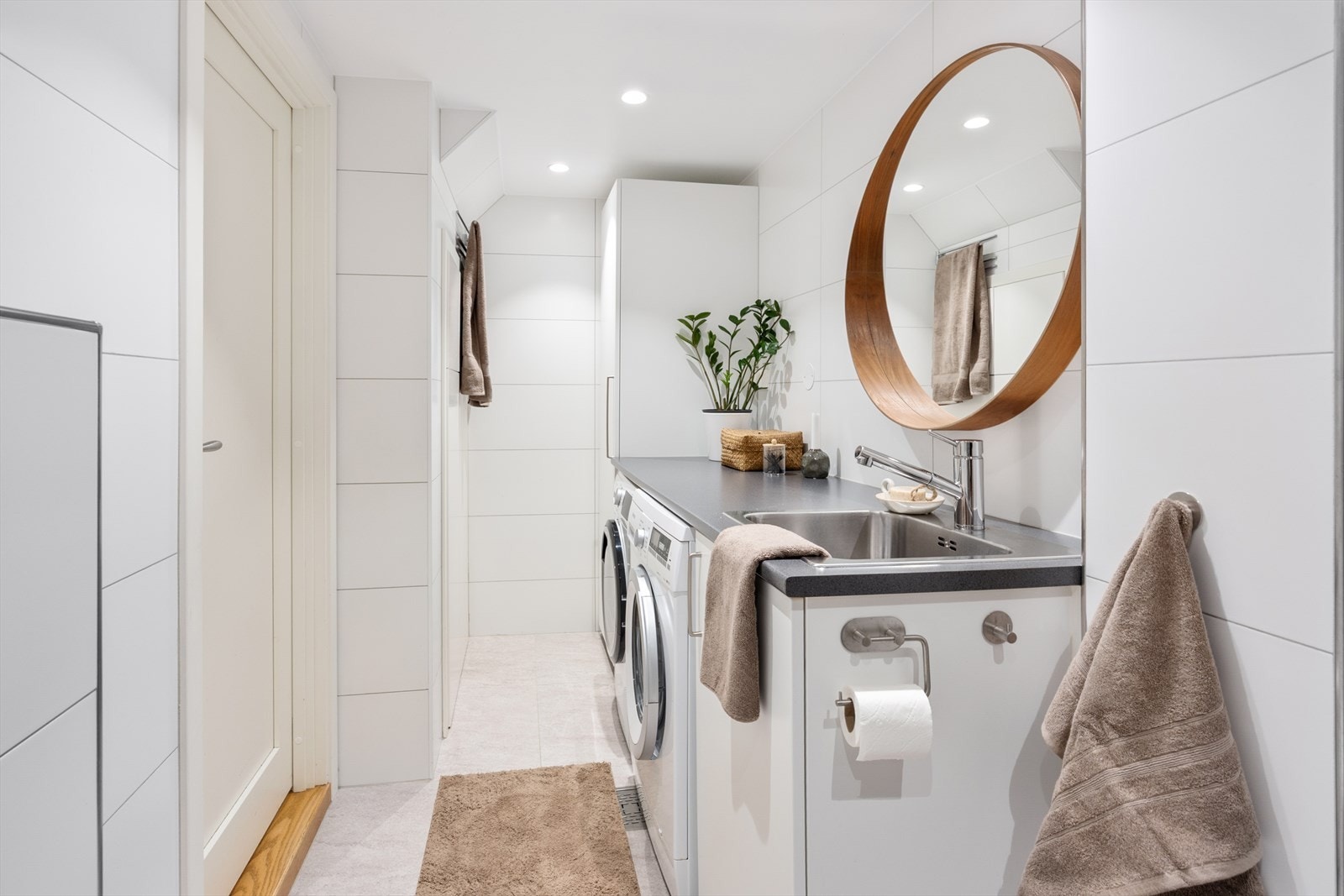 I andre enden av badet er det en praktisk arbeidsbenk med utslagsvask, høyskap, samt opplegg for vaskemaskin og tørketrommel. Galleribilde