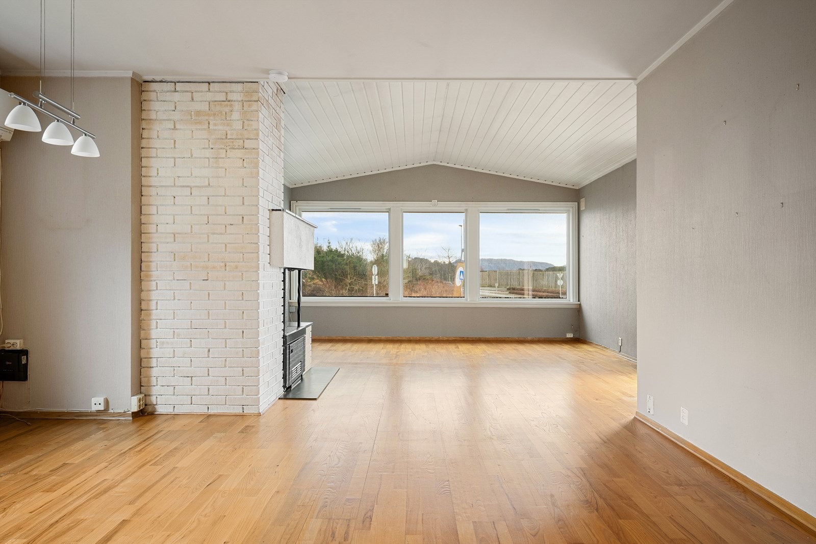 Romslig stue med en sentralt plassert peis som skaper en lun atmosfære. Galleribilde