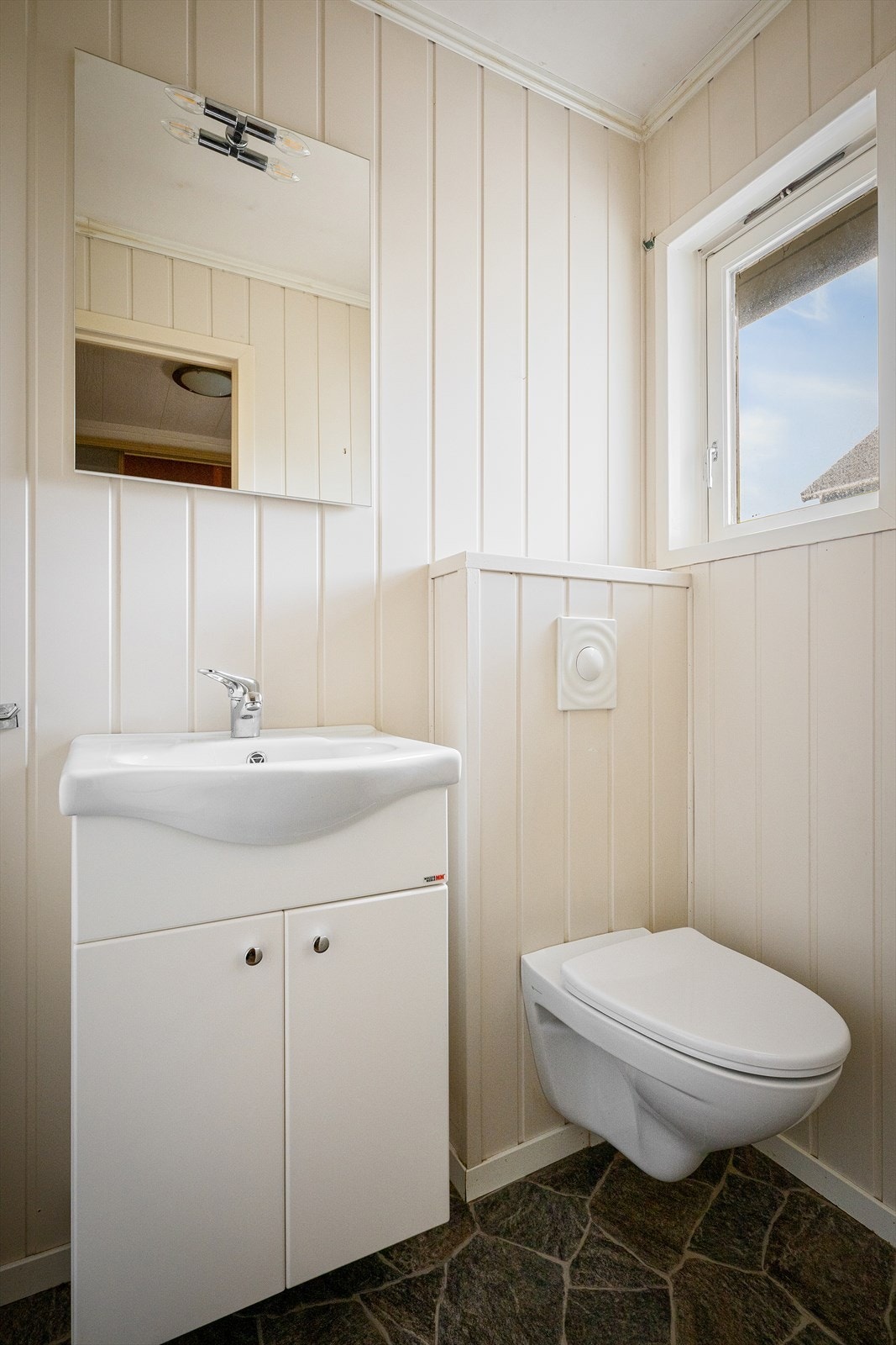 Separat toalettrom i hovedetasjen, utstyrt med vegghengt toalett og servant. Galleribilde