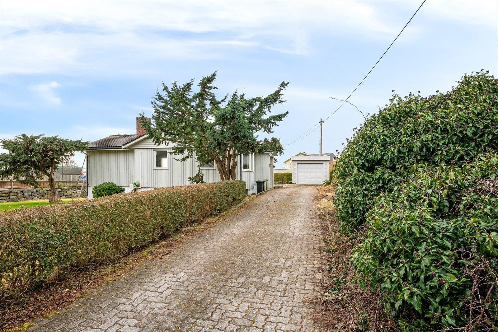 Egen innkjørsel med belegningsstein fører frem til garasjen. Galleribilde
