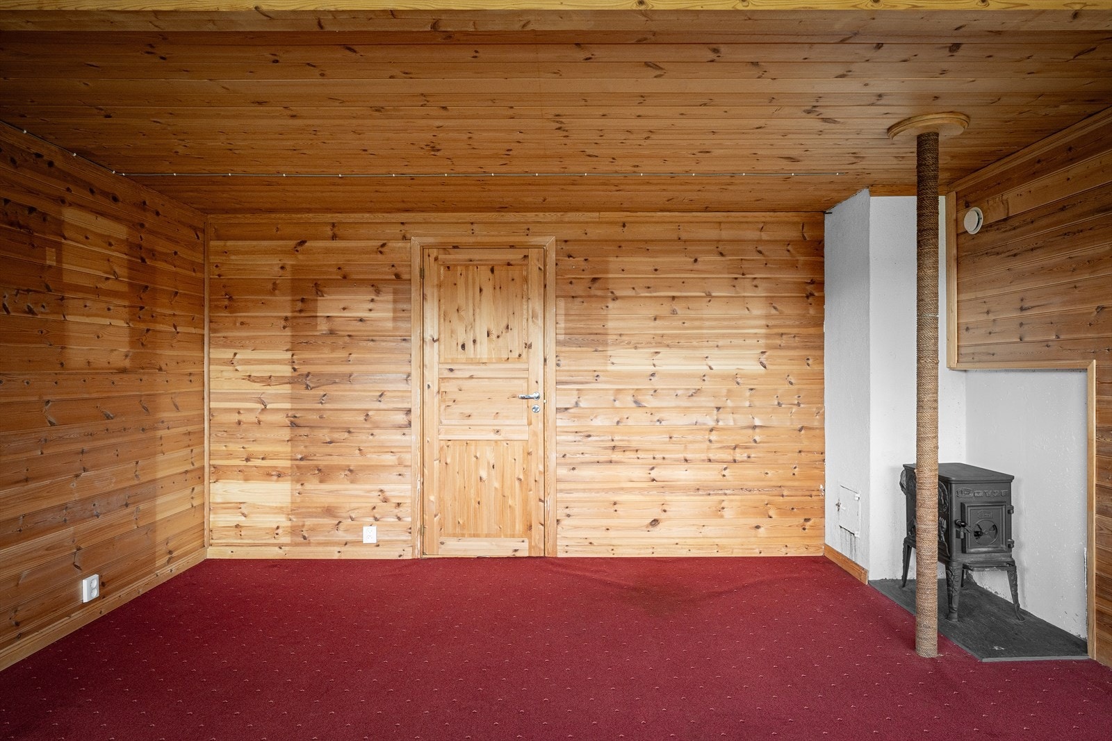 Rom i kjeller innredet som kjellerstue sørger en vedovn for ekstra varme og hygge. Galleribilde