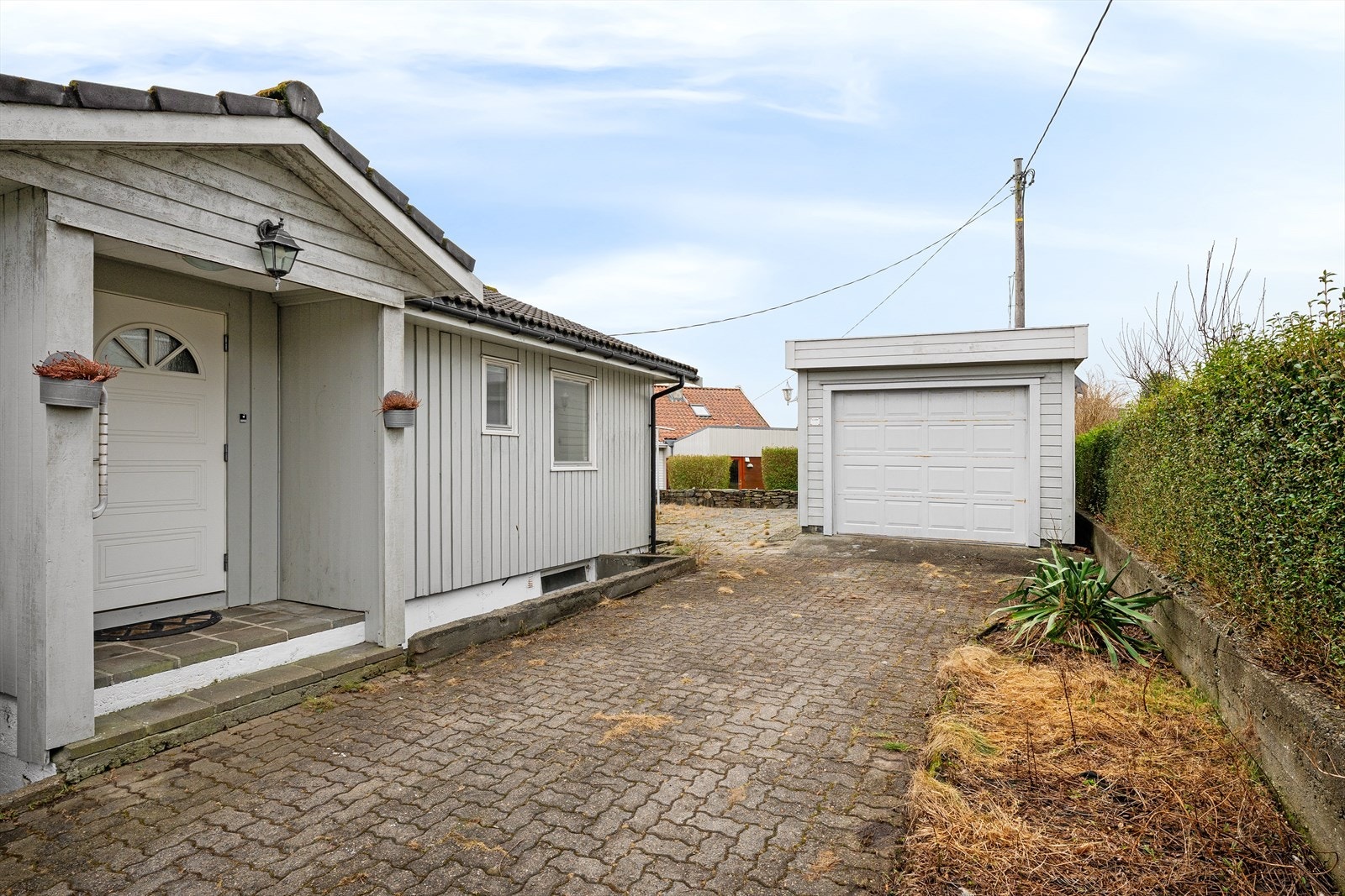 Garasjen har motorisert leddport og en integrert bod på 7 m². Galleribilde