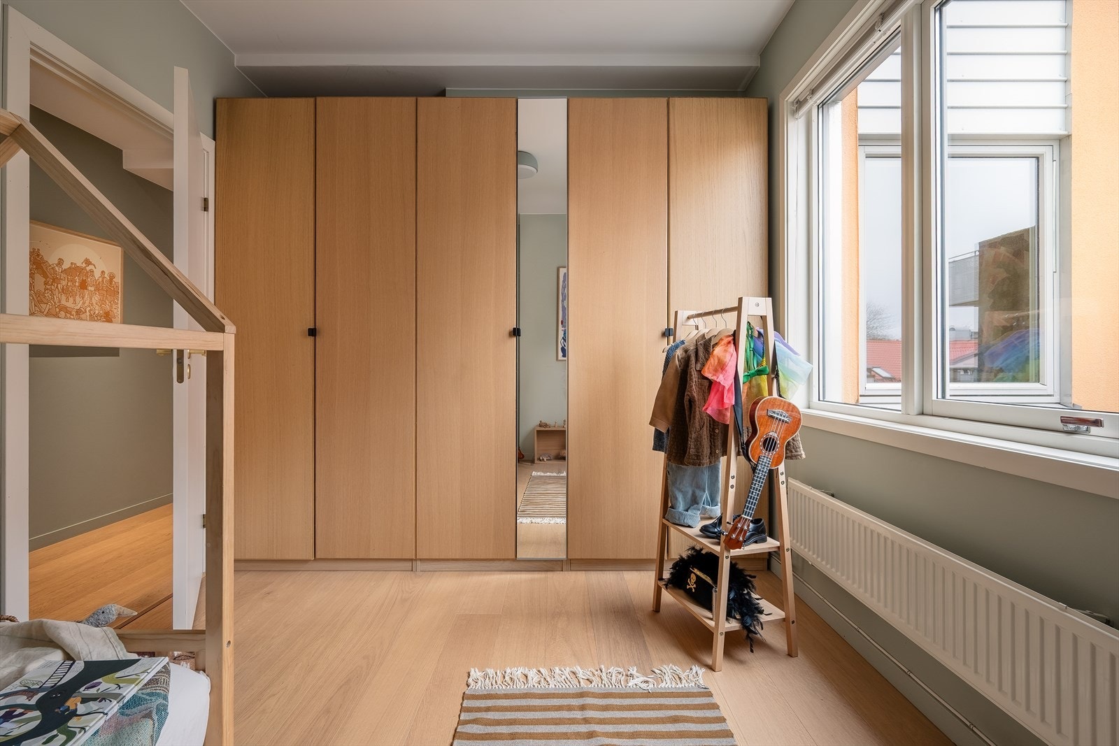 Den ene veggen er fullt utbygget med garderobeskap, som gir masser av plass til å oppbevare klær og tilbehør. Galleribilde