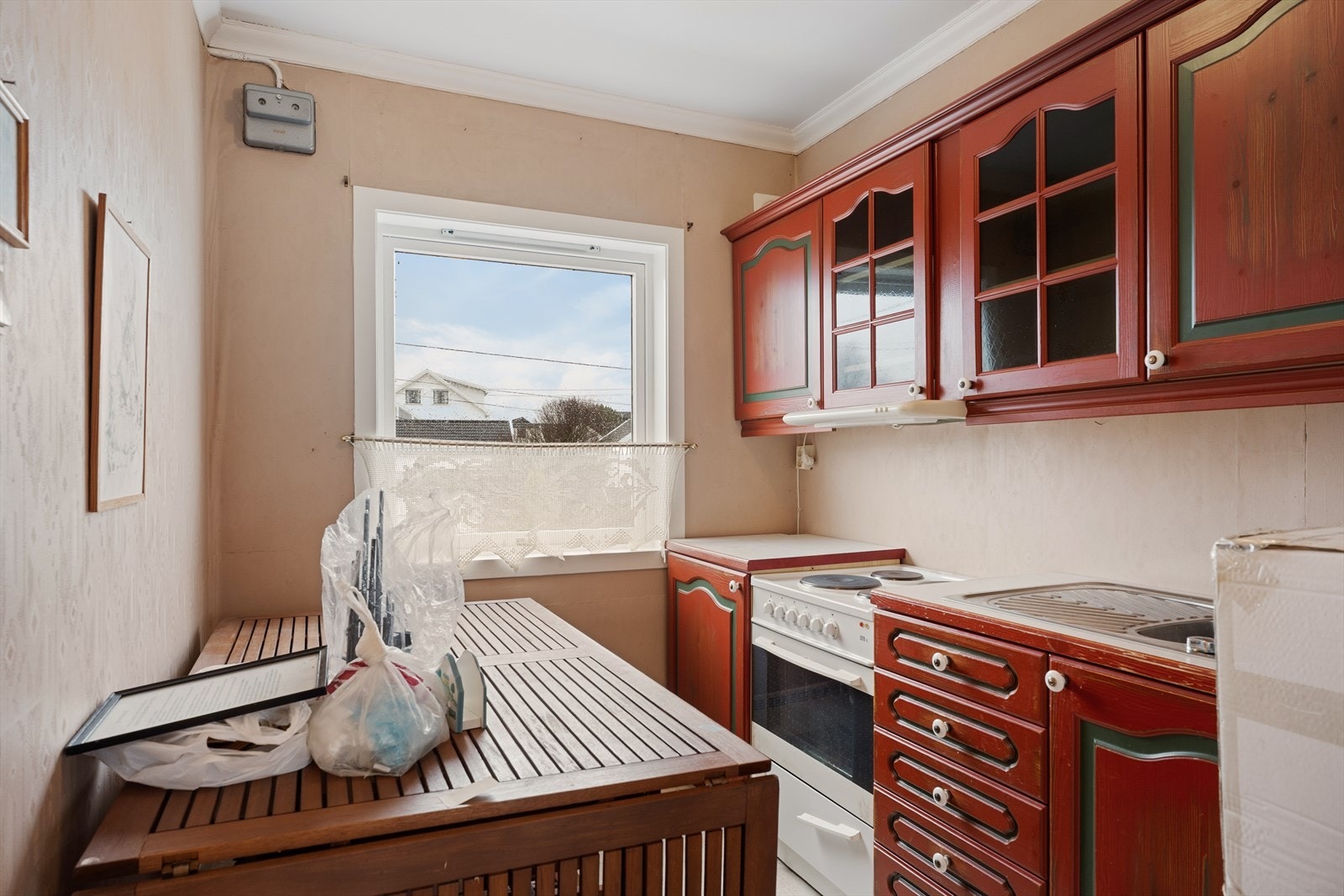 Kjøkkenet på loftet har kjøkkeninnredning med profilerte fronter og laminat benkeplate - alle hvitevarene er frittstående Galleribilde