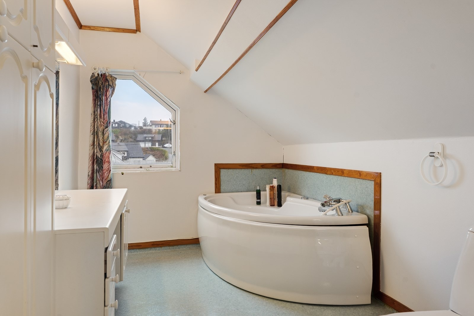 Badet på loftet har vinylbelegg på gulvet, strie på veggene og takplater i himlingen Galleribilde