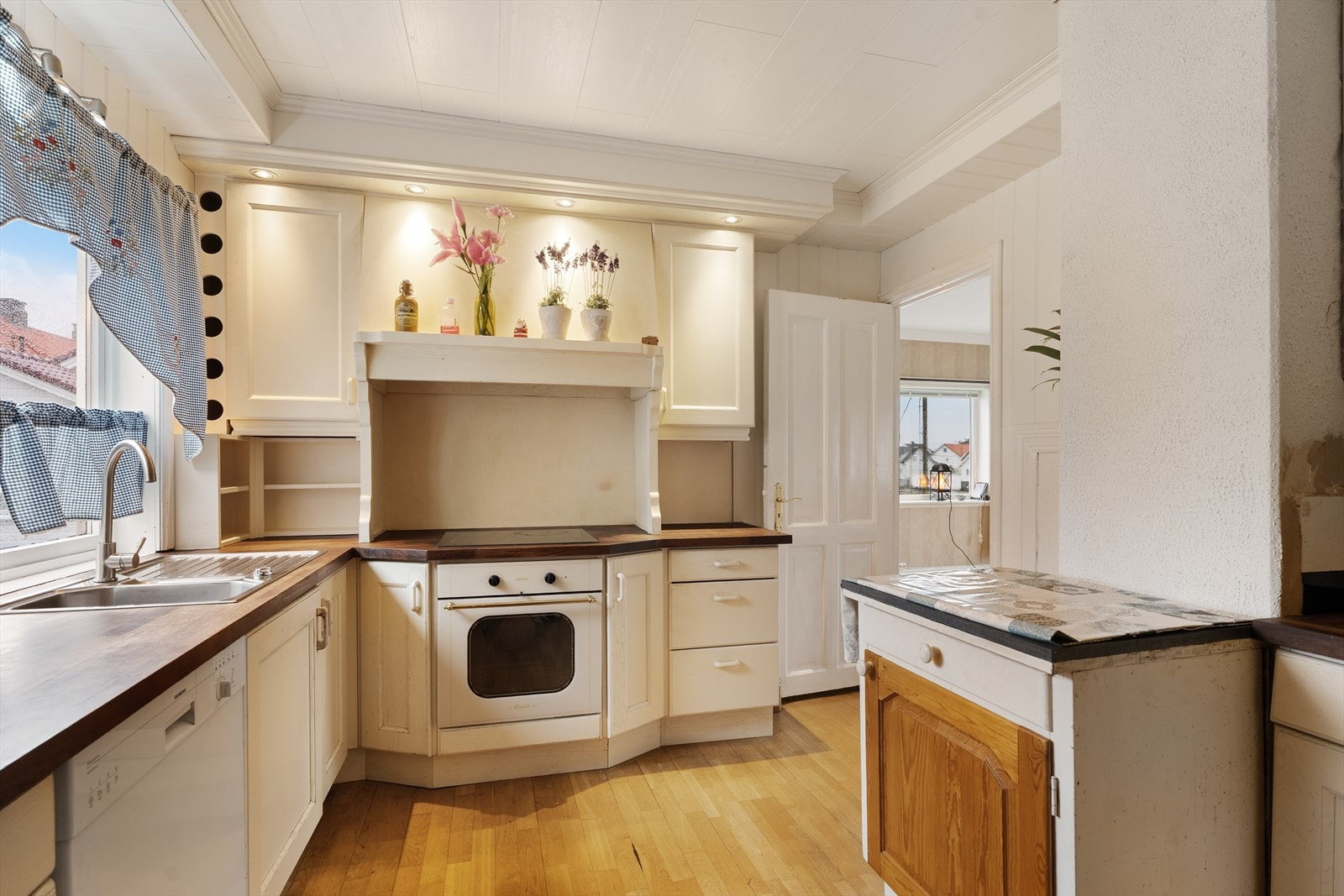 Kjøkkenet har innredning med profilerte fronter og heltre benkeplate Galleribilde