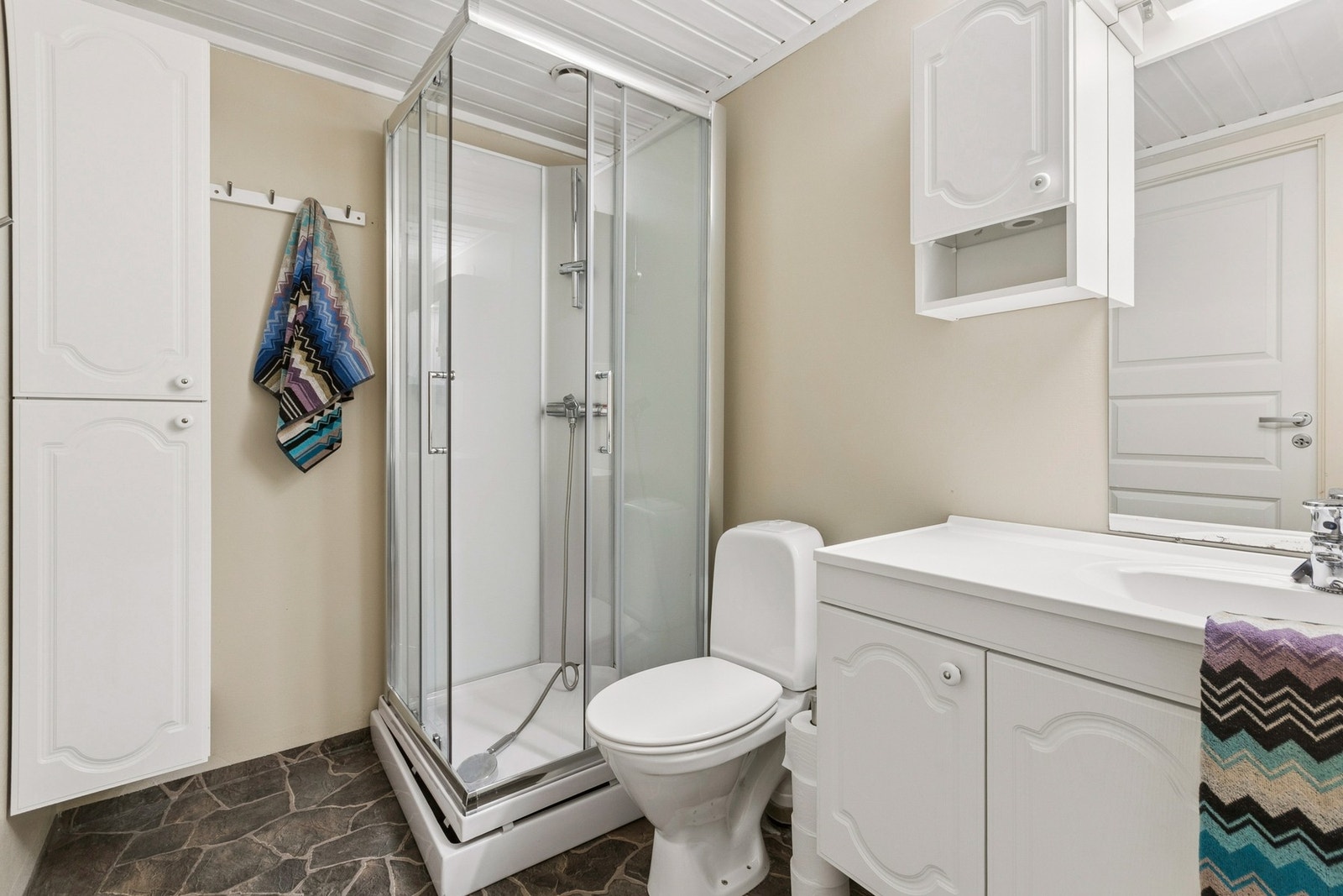 Badet er innredet med nedfelt servant, toalett, dusjkabinett og opplegg for vaskemaskin. Galleribilde