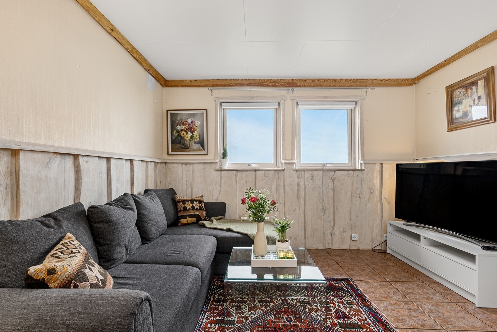 Flislagt gulv og panelvegger preger stueområdet. Galleribilde