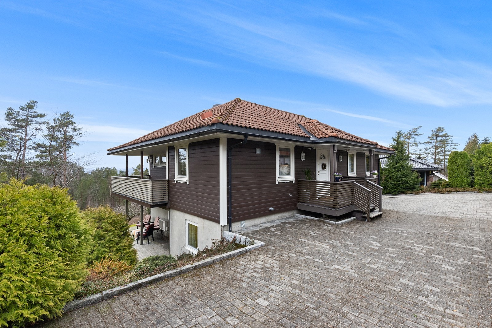 Tomten er skrånende og opparbeidet med plen og beplantning. Galleribilde