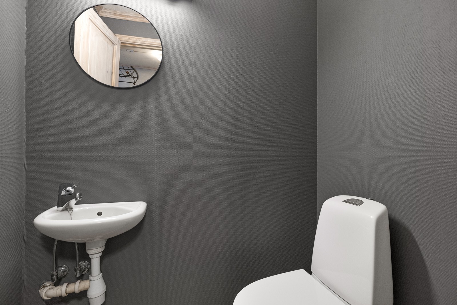 Toalettrommet i 1. etasje har flislagt gulv og er utstyrt med enkel servant og toalett. Ventilasjon skjer via en ventil i himlingen koblet til loftsvifte. Galleribilde