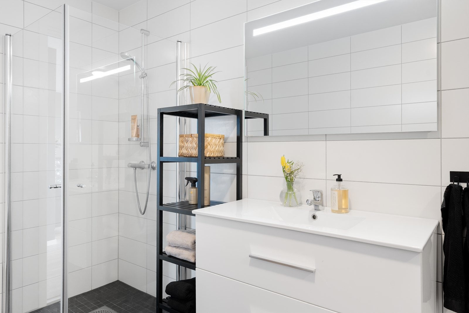 Varmtvannsbereder og opplegg for vaskemaskin bak skyvedører med speil på badet Galleribilde