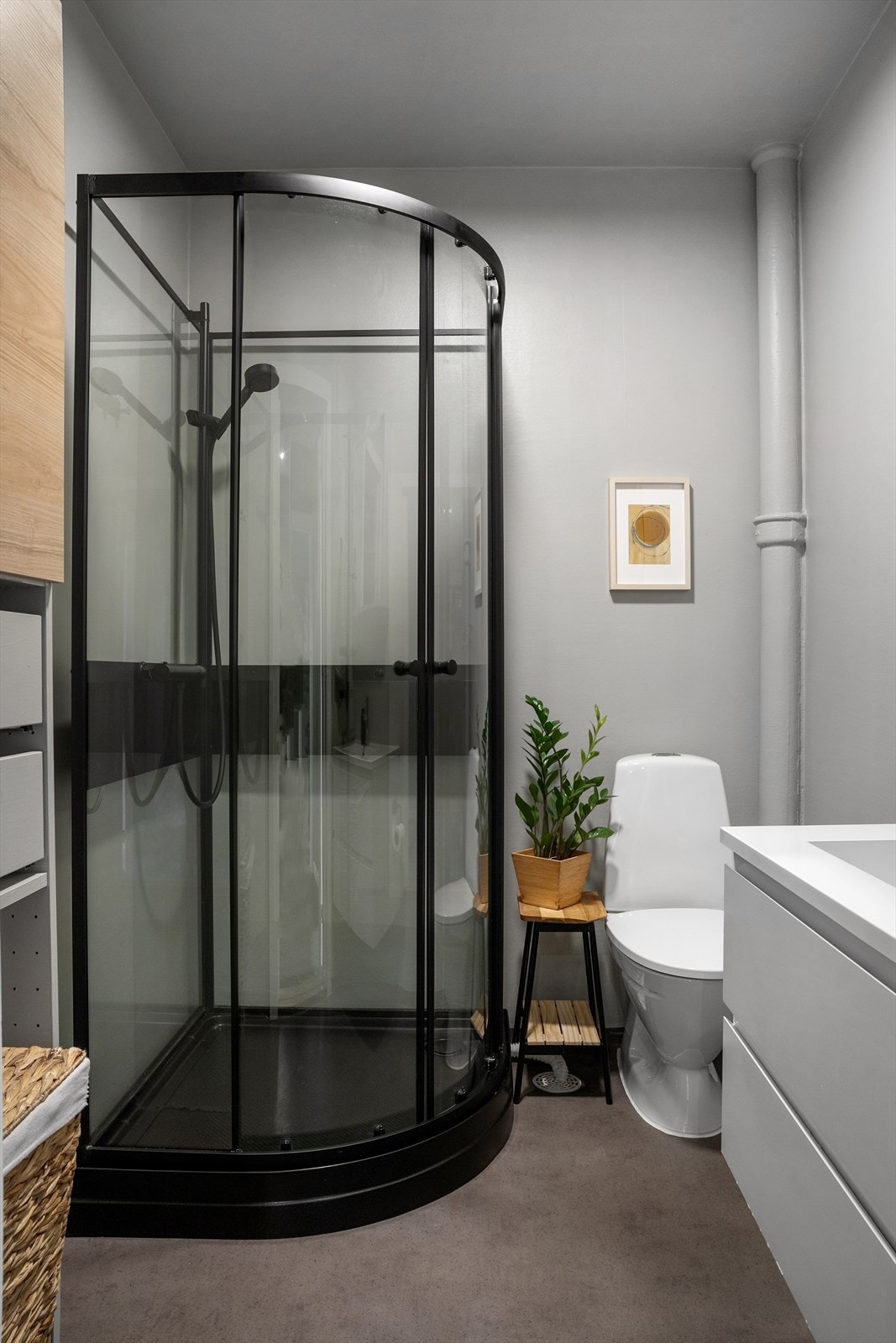 Godt med oppbevaring og moderne innredning med tett dusjkabinett i sorte detaljer, og med seksjon, speilskap, samt mulighet for ekstra skapplass. Galleribilde