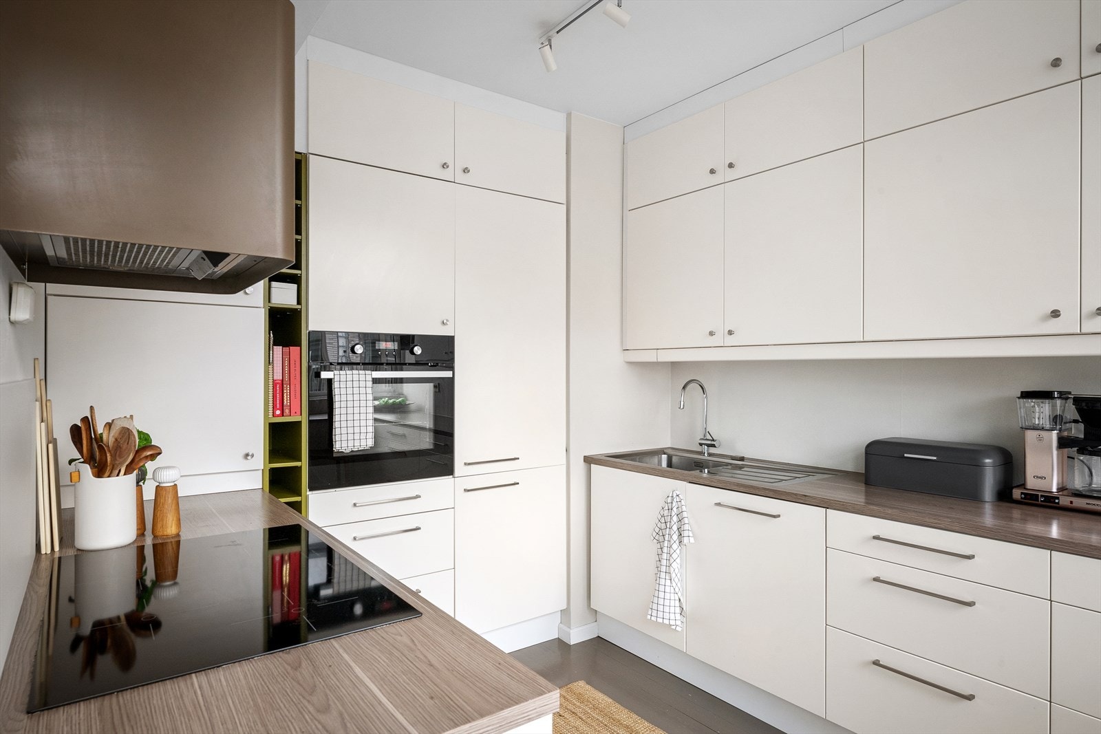 Delikat designvifte bryter fint med de lyse frontene og skaper varme. Optimalt plasserte arbeidssoner og hvitevarer for funksjonalitet. Galleribilde