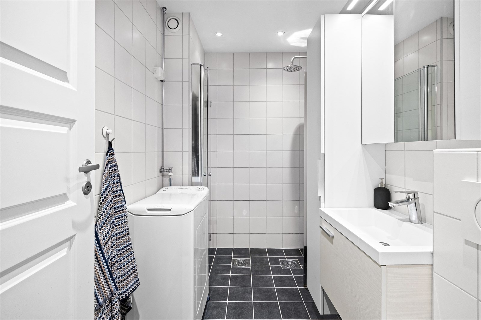 Badet har gulvvarme og downlights. Videre er det vegghengt toalett, regnfallsdusj og opplegg til vaskemaskin. Galleribilde