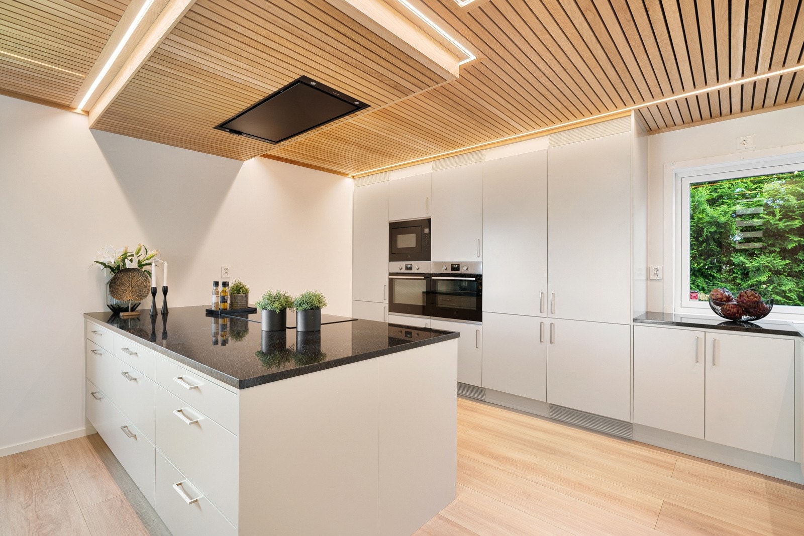 Integrerte hvitevarer som induksjonstopp, to stekeovner, kjøleskap, kombiskap, fryser og oppvaskmaskin. Galleribilde