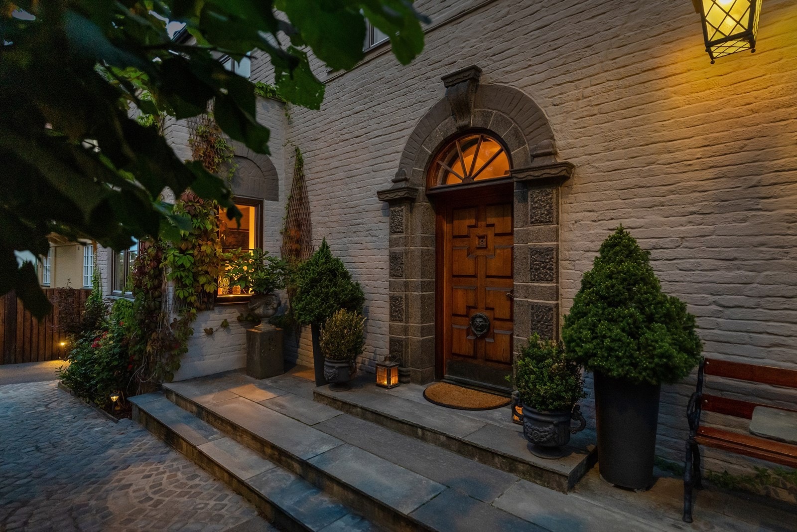 Inngangspartiet har vakre, originale detaljer på inngangsdøren og er oppgradert med naturstein mot porten Galleribilde