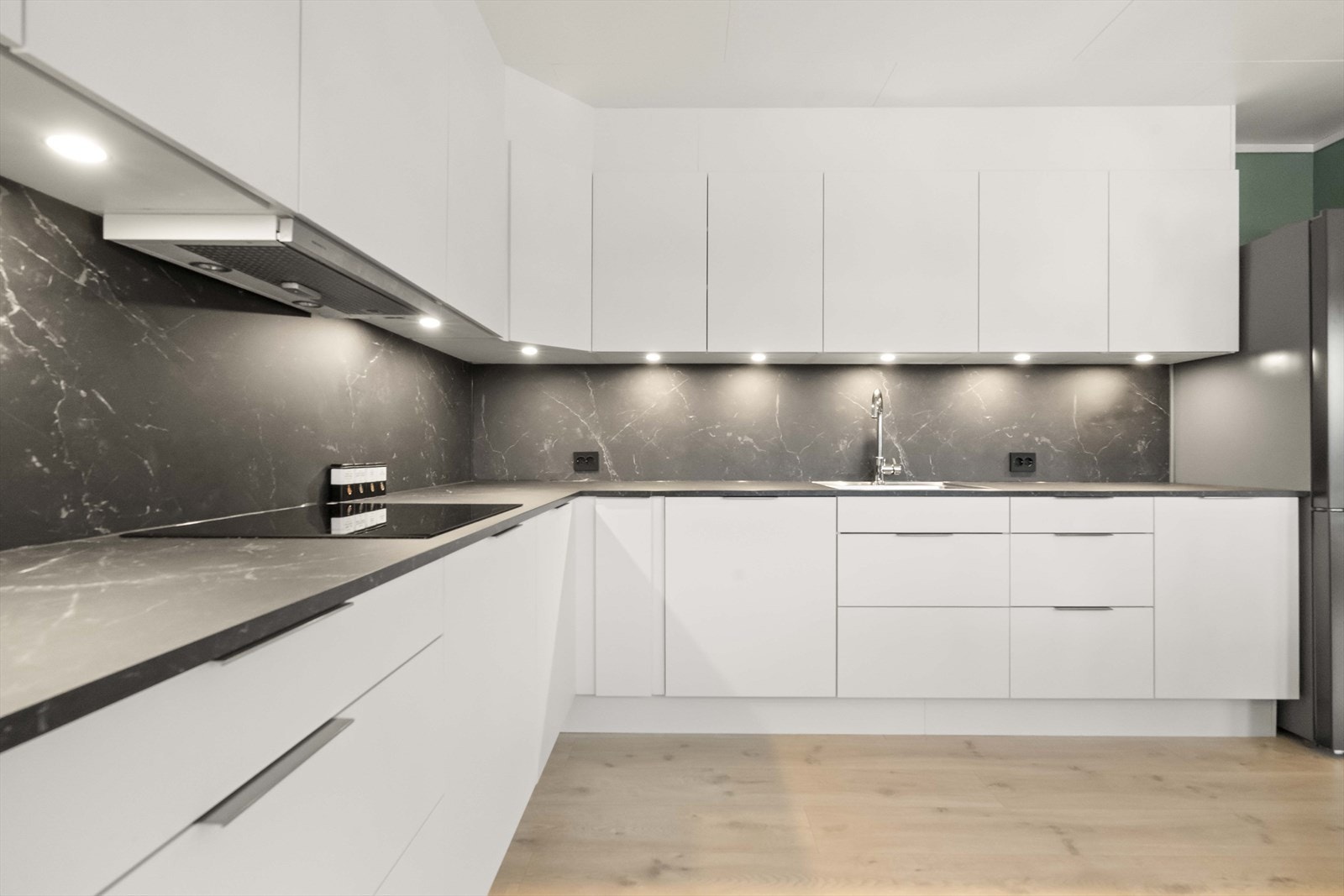 Kjøkkenet har ei stilrein innredning frå HTH med lyse fronter og mørk benkeplate Galleribilde