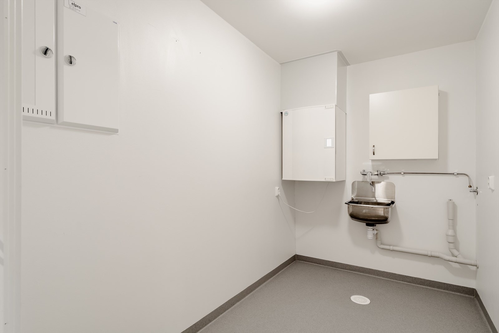 Vaskerom/teknisk rom med sluk og opplegg for vaskemaskin. Galleribilde