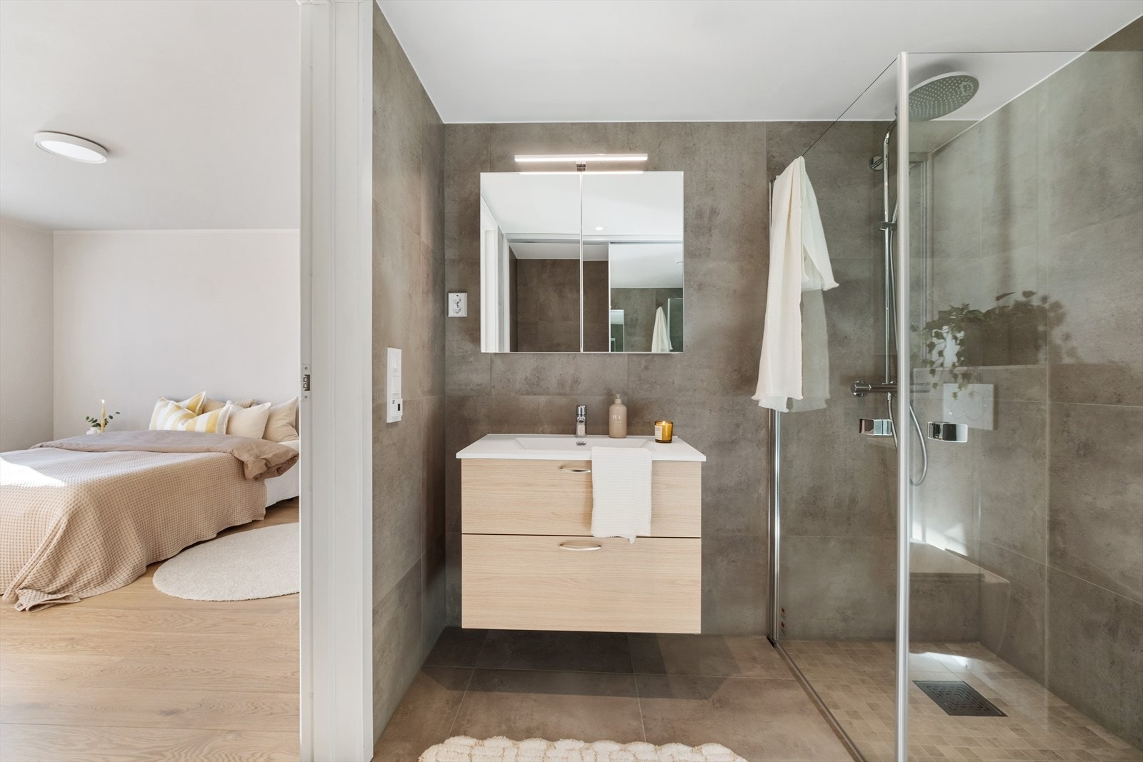 Badet er moderne og gjennomført med flislagte overflater, elektriske varmekabler i gulvet og innfelte spotter i taket som gir en lys og behagelig atmosfære Galleribilde