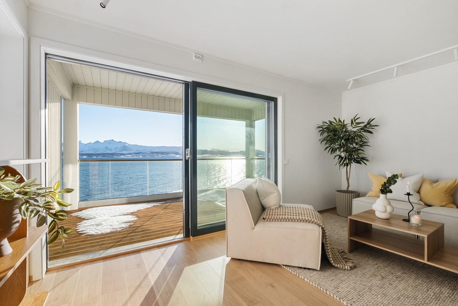 Stuen er utført i lyse farger og har store vindusflater som slipper inn rikelig med naturlig lys, noe som skaper en luftig og innbydende atmosfære i rommet Galleribilde