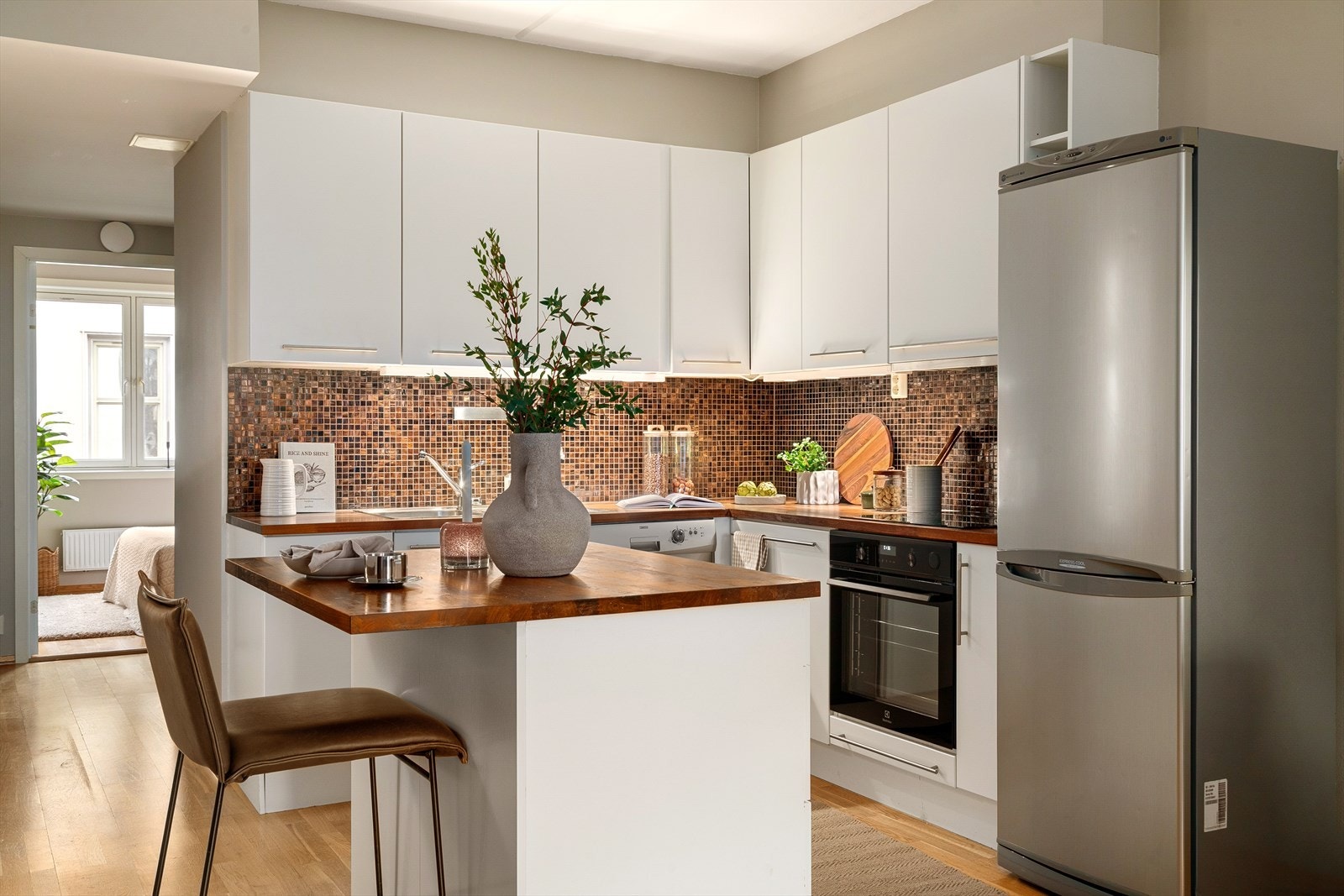 Åpent og funksjonelt kjøkken med heltre benkeplate og integrert platetopp og stekeovn. Kjøleskap og oppvaskmaskinen medfølger Galleribilde