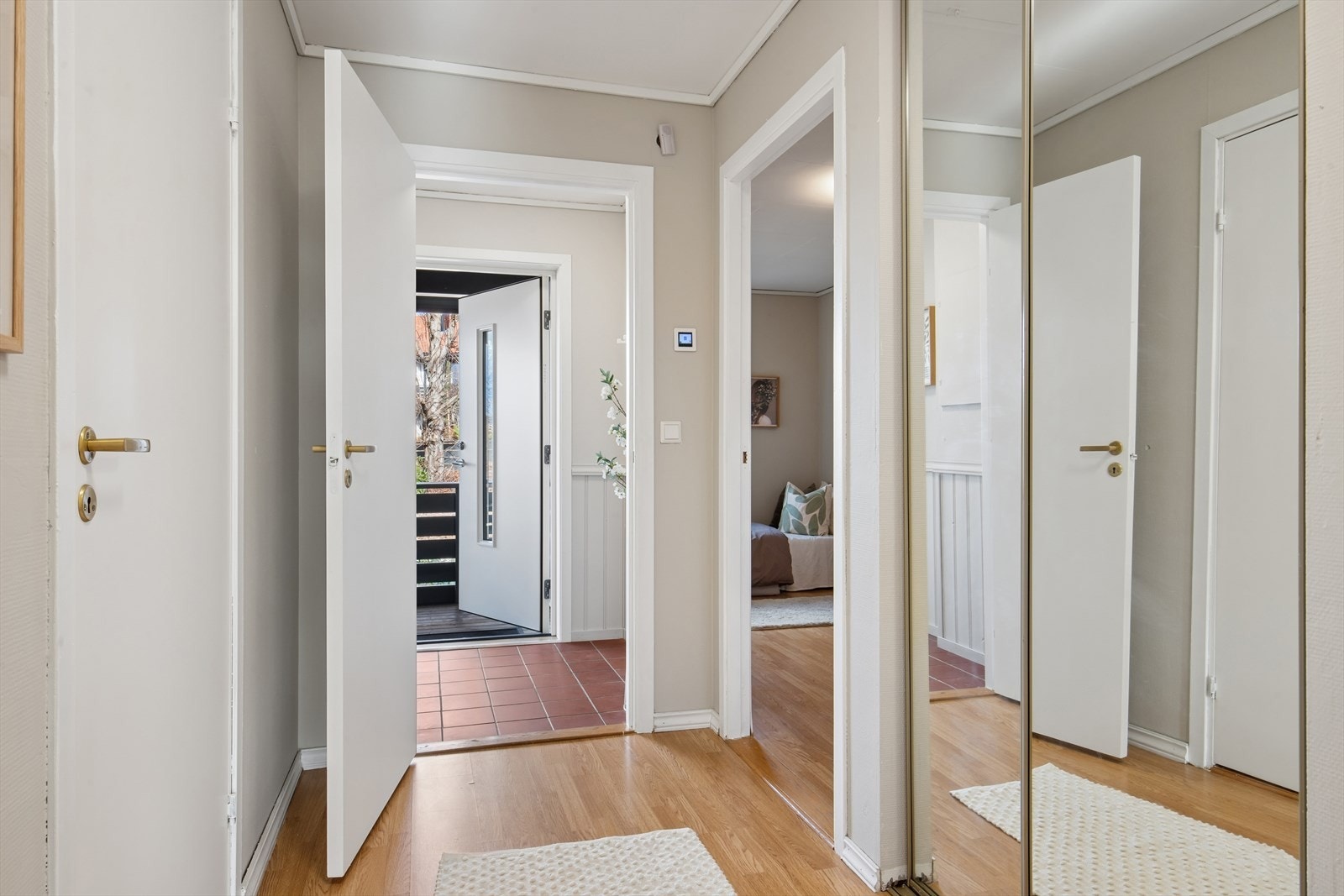 Skyvedørsgarderobe med speilfronter i gangen gir rikelig med oppbevaringsplass for yttertøy. Galleribilde