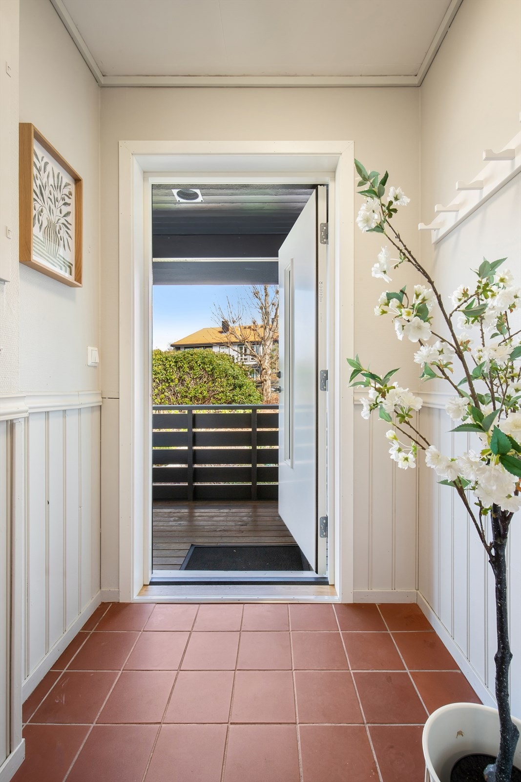 Du ønskes velkommen inn i en entré med fliser på gulvet. Hovedytterdøren, skiftet i 2025, gir et godt førsteinntrykk og leder deg videre inn i leiligheten. Galleribilde