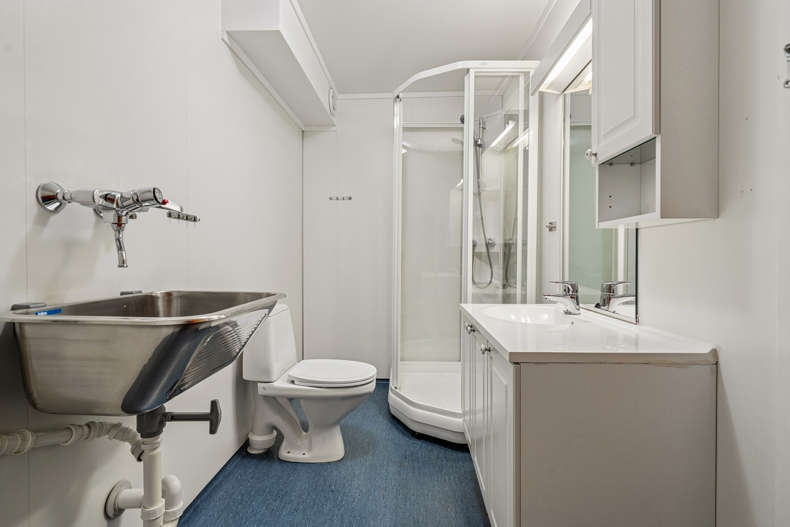 Baderommet er innredet med servant med underskap, utslagsvask, wc og dusjkabinett. Galleribilde