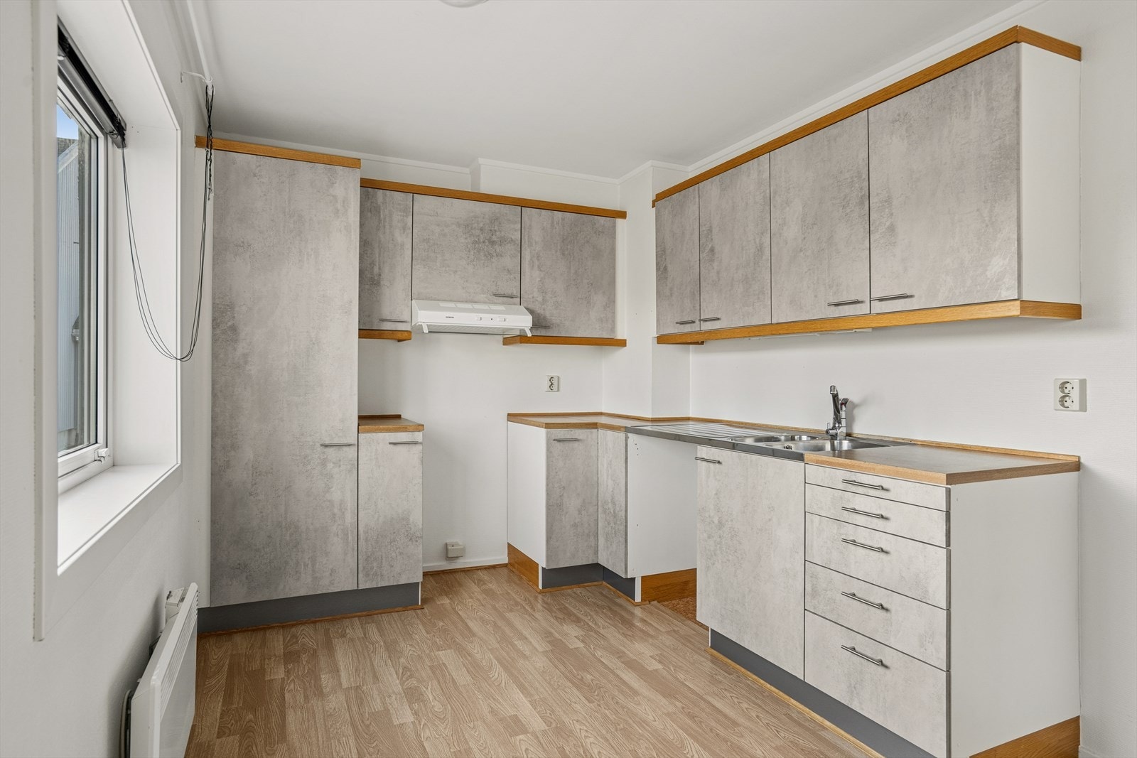 Kjøkkeninnredning med fronter i foliert grå slett utførelse. Normalt utbygget med benker og overskap. Galleribilde