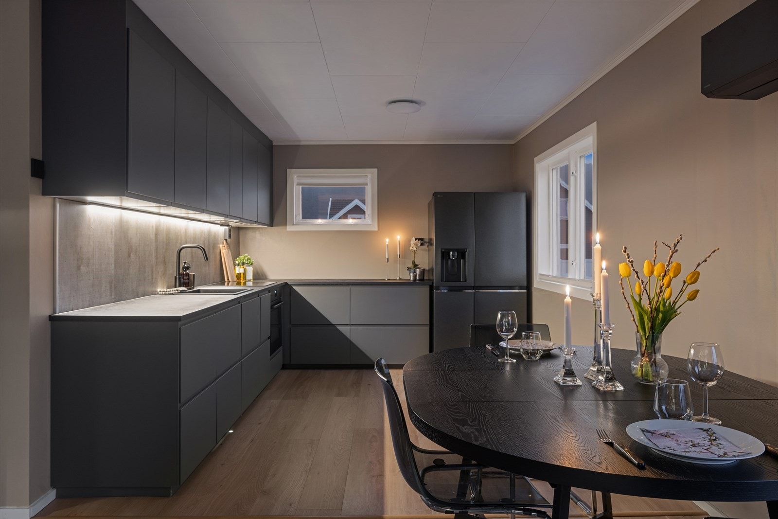 Kjøkkenet ble oppgradert i oktober 2025, og fremstår moderne med grå fronter og sort laminert benkeplate. Galleribilde