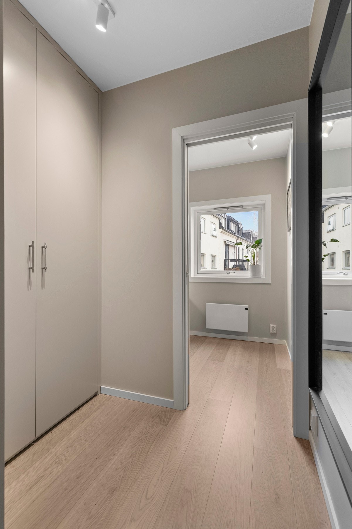 Entreen glir sømløst over i en mellomgang, innredet med et plassbygd garderobeskap fra 2022. Galleribilde