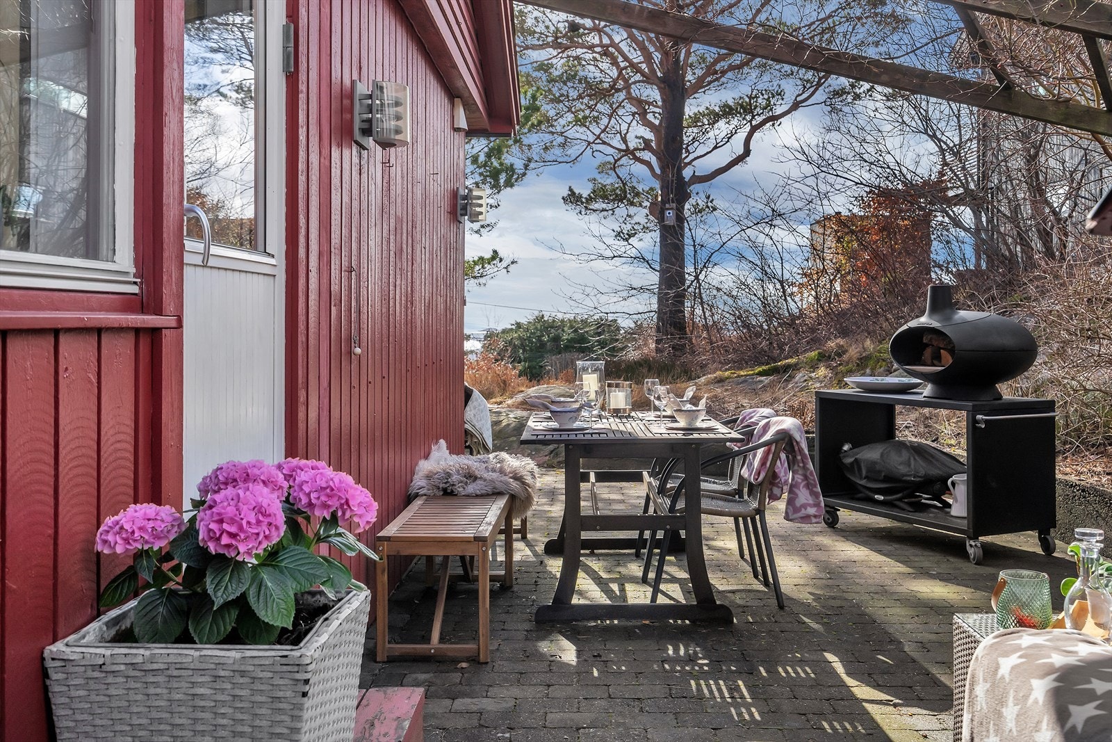 Fra stuen er det utgang til et nydelig uteområde med pergola - et perfekt sted for stille sommerkvelder eller sosiale sammenkomster Galleribilde