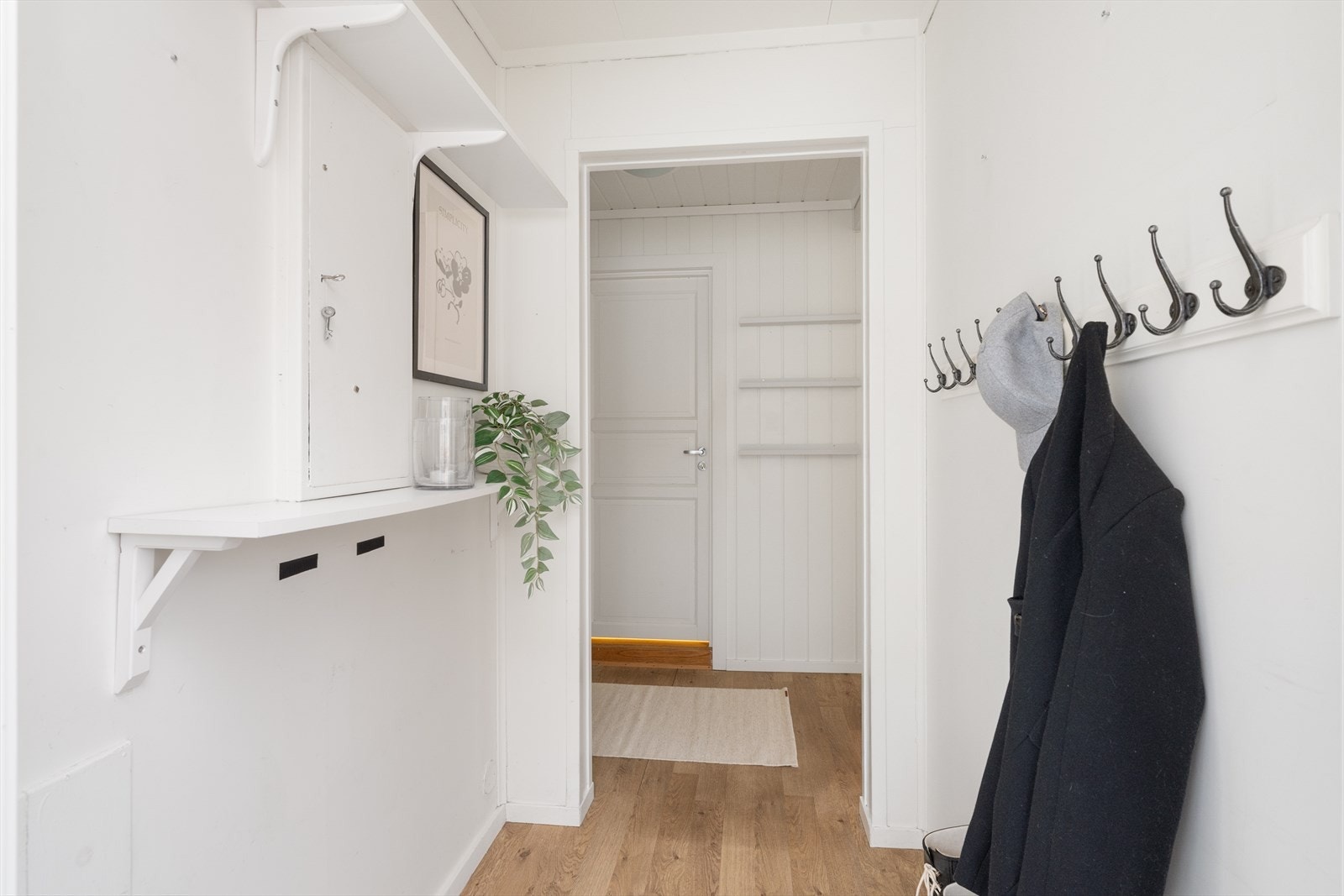 Med adkomst fra det hyggelige overbygde inngangspartiet kommer man inn i boligens lyse gangarealer hvor det er plass til klesoppbevaring både på fastmonterte knagger og i garderobeskap. Galleribilde