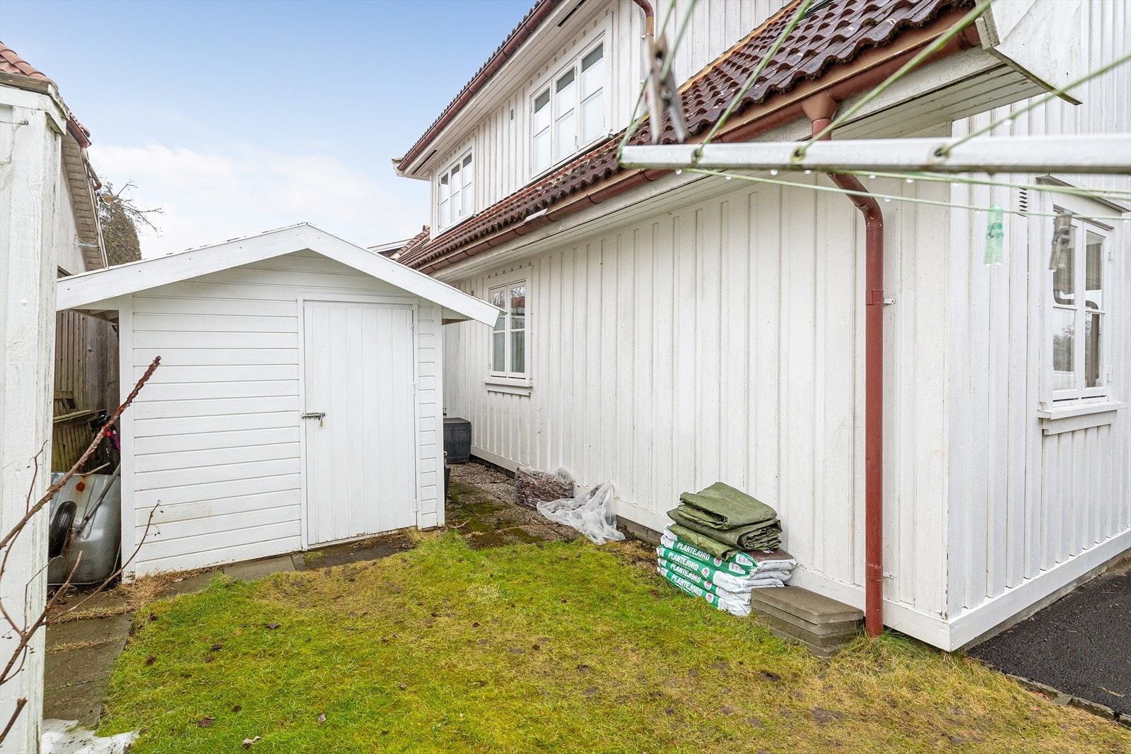 Det er også en liten hageflekk i bakkant av gårdsplassen, med tørkestativ og en praktisk redskapsbod. Galleribilde