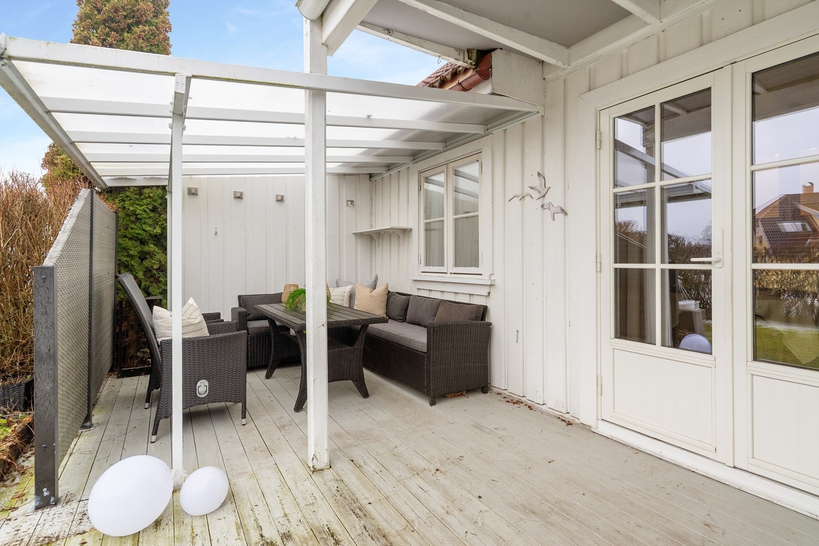 Deler av terrassen har takoverbygg og levegger som skaper en lun og koselig uteplass. Galleribilde