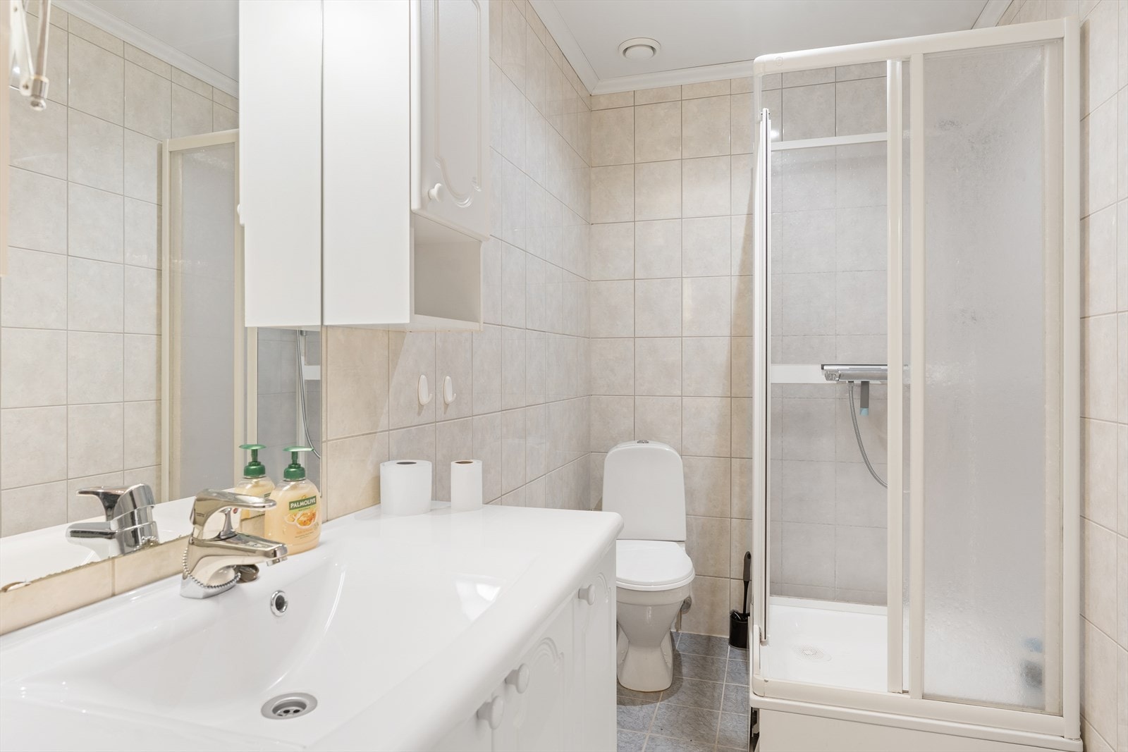 Badet inneholder innredning med servant, toalett, dusjkabinett og opplegg for vaskemaskin Galleribilde