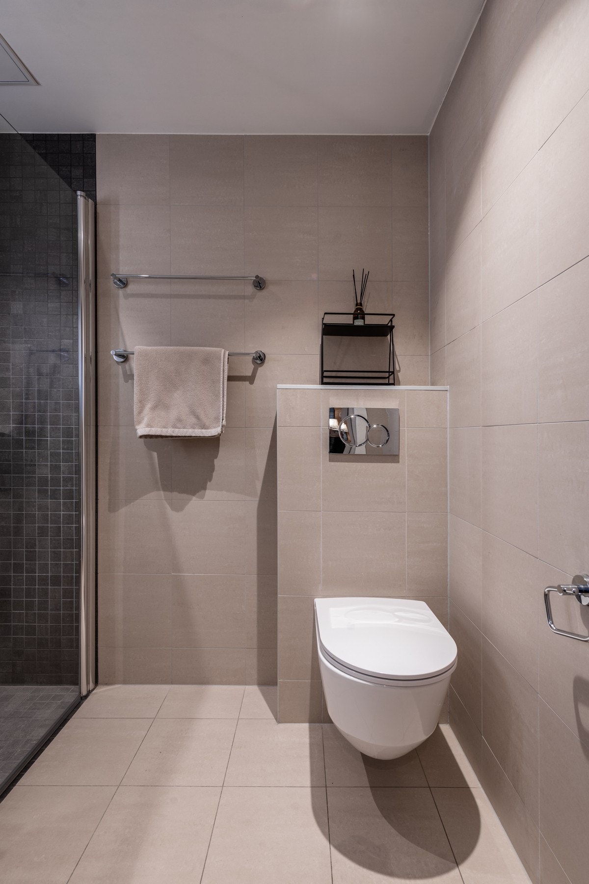 Badet er utstyrt med servantinnredning, vegghengt toalett og dusj med glassdører Galleribilde